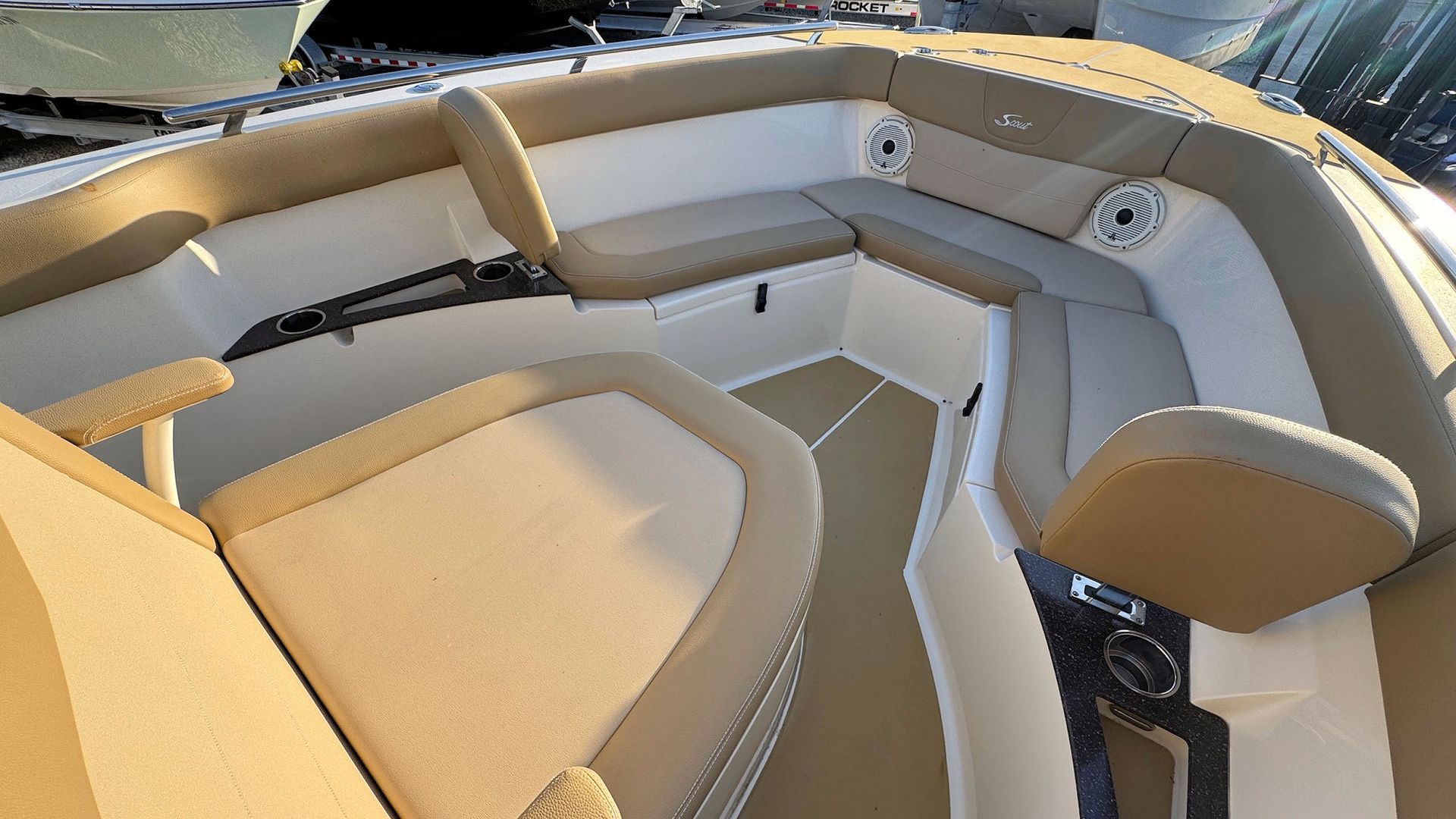Beige upholstered boat seating with cup holder on a sunlit deck