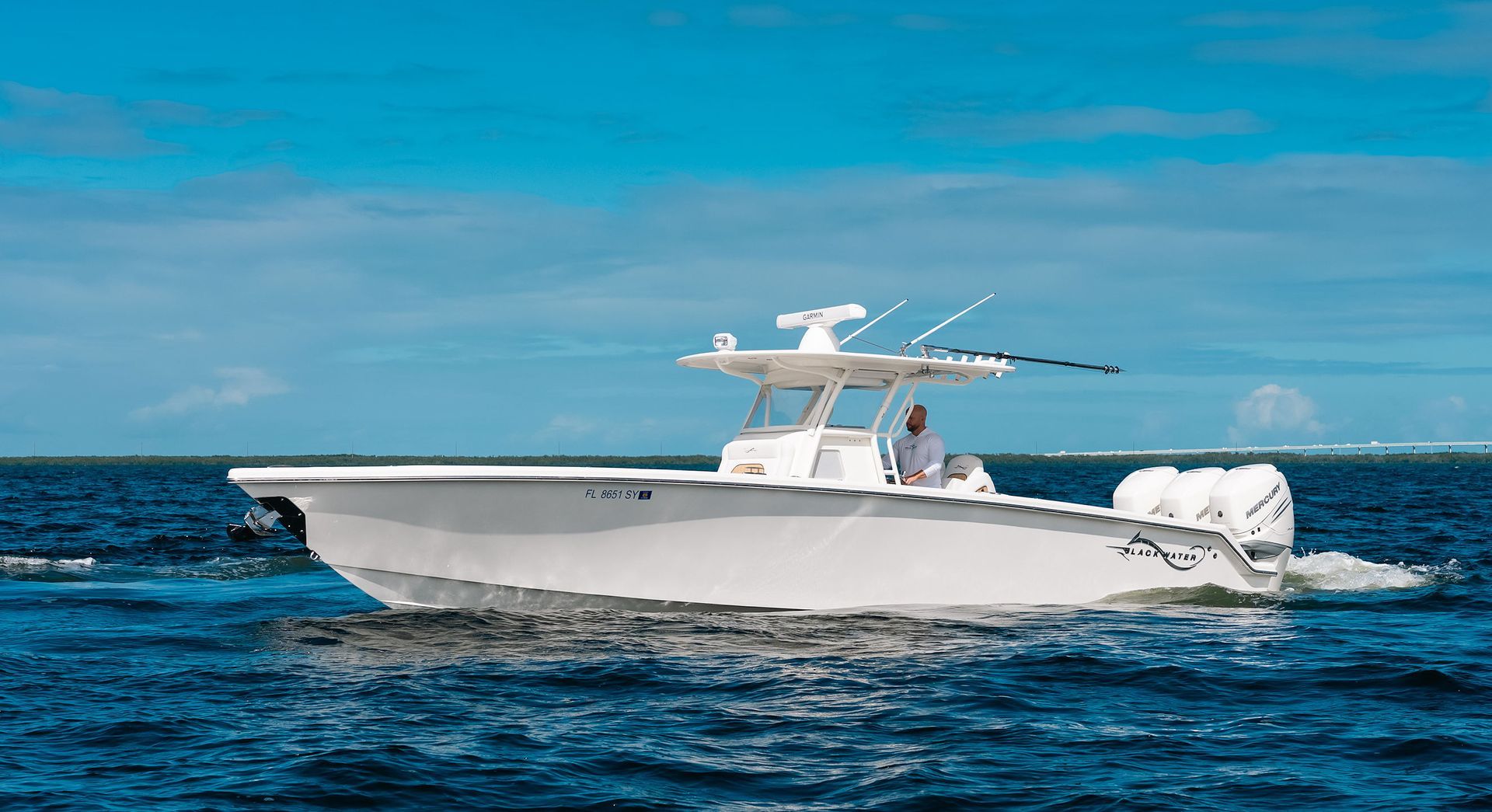 White motorboat cruising on blue ocean under a clear sky