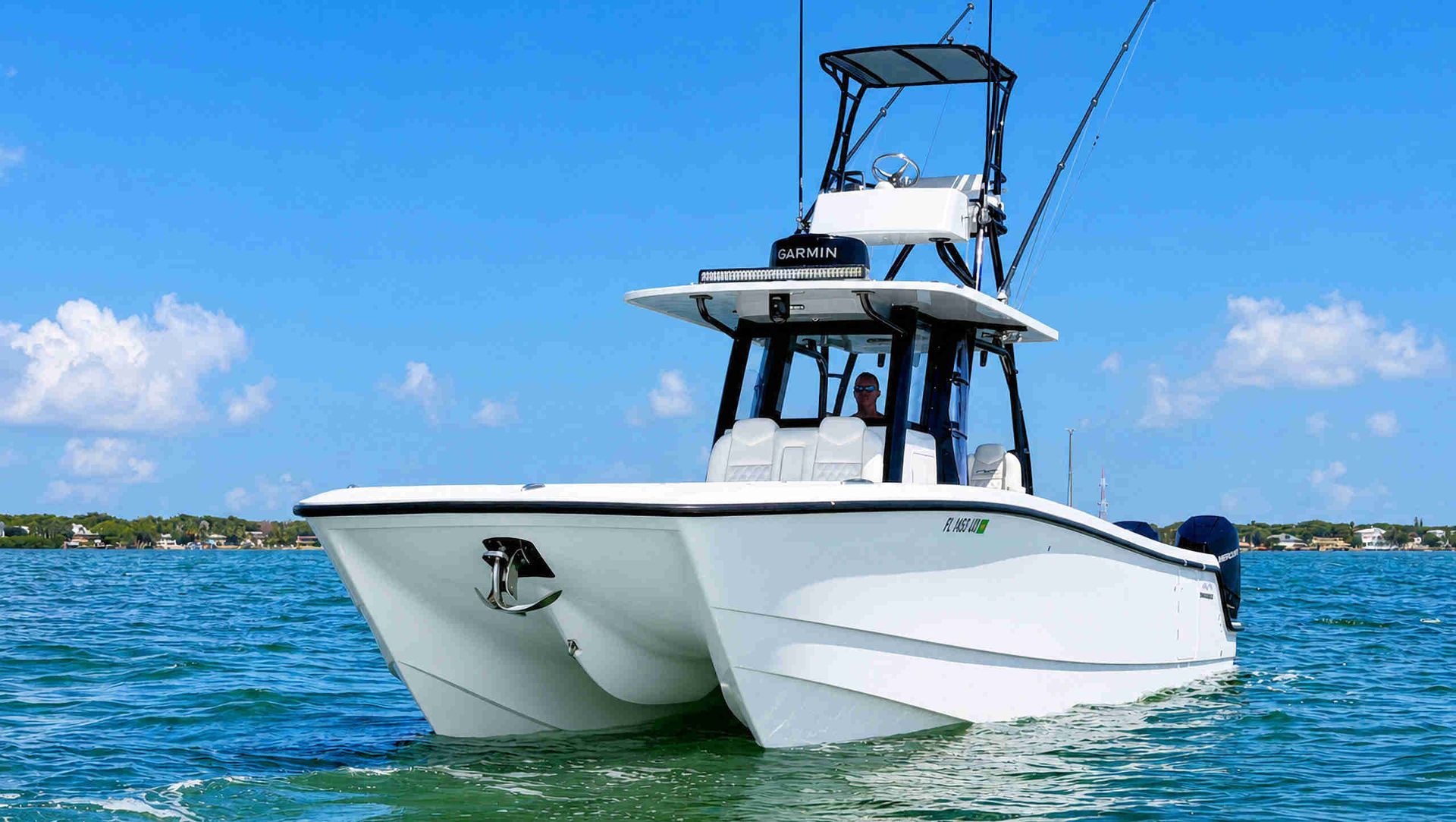 White catamaran center console fishing boat on blue water under a clear sky