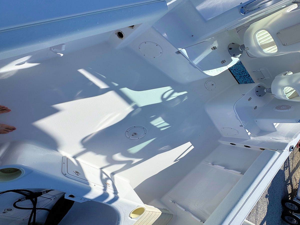 White boat deck with open compartments. Bright sunlight casts shadows.