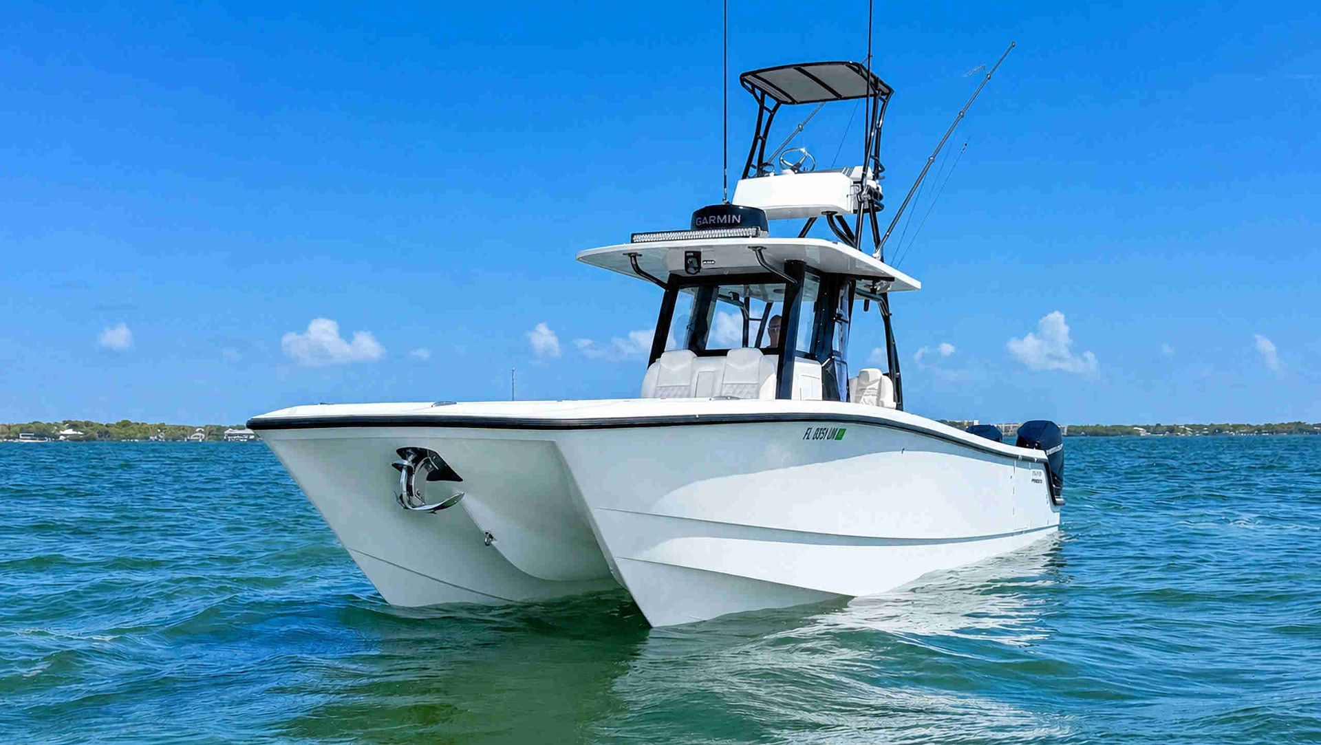 White catamaran center console fishing boat on blue water under a clear sky