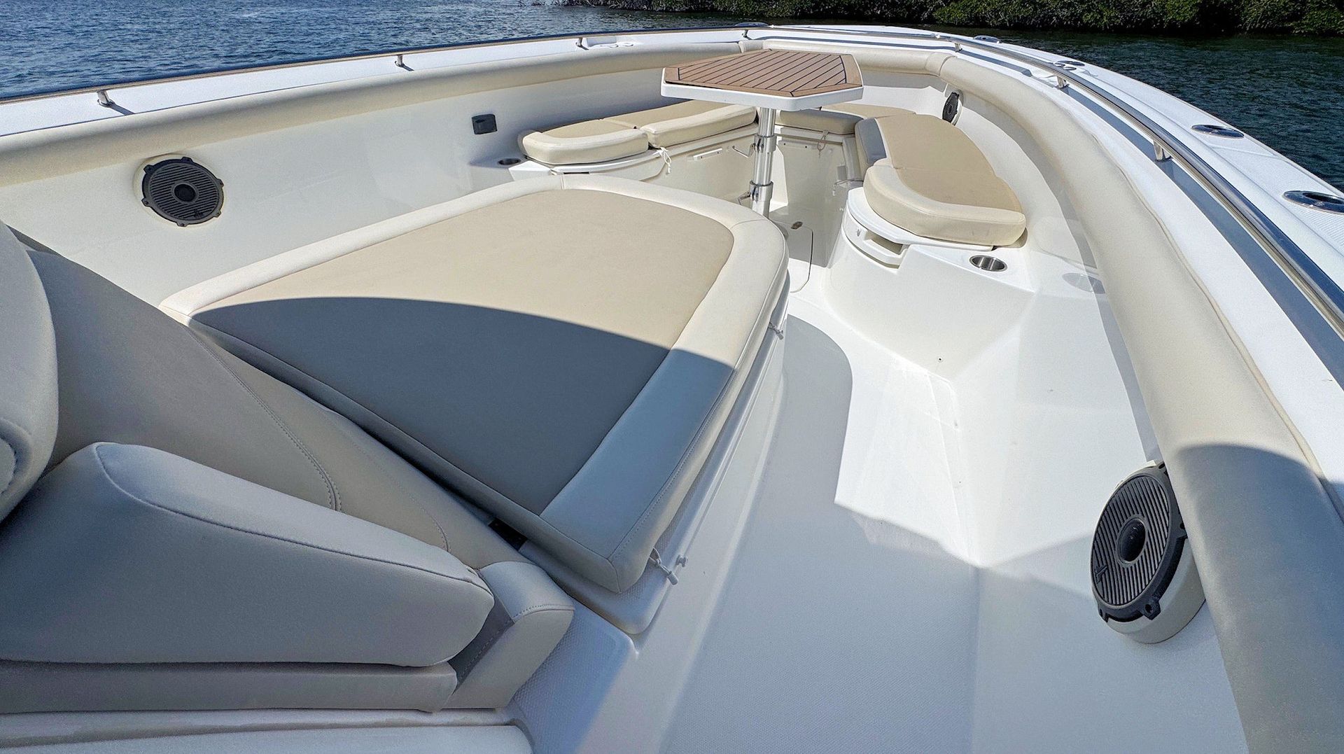 Boat bow seating area with white and gray cushions on a sunny day at sea