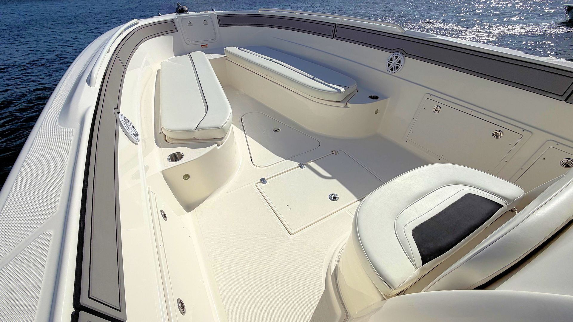 Forward bow  with cushioned seating on calm water under bright sunlight