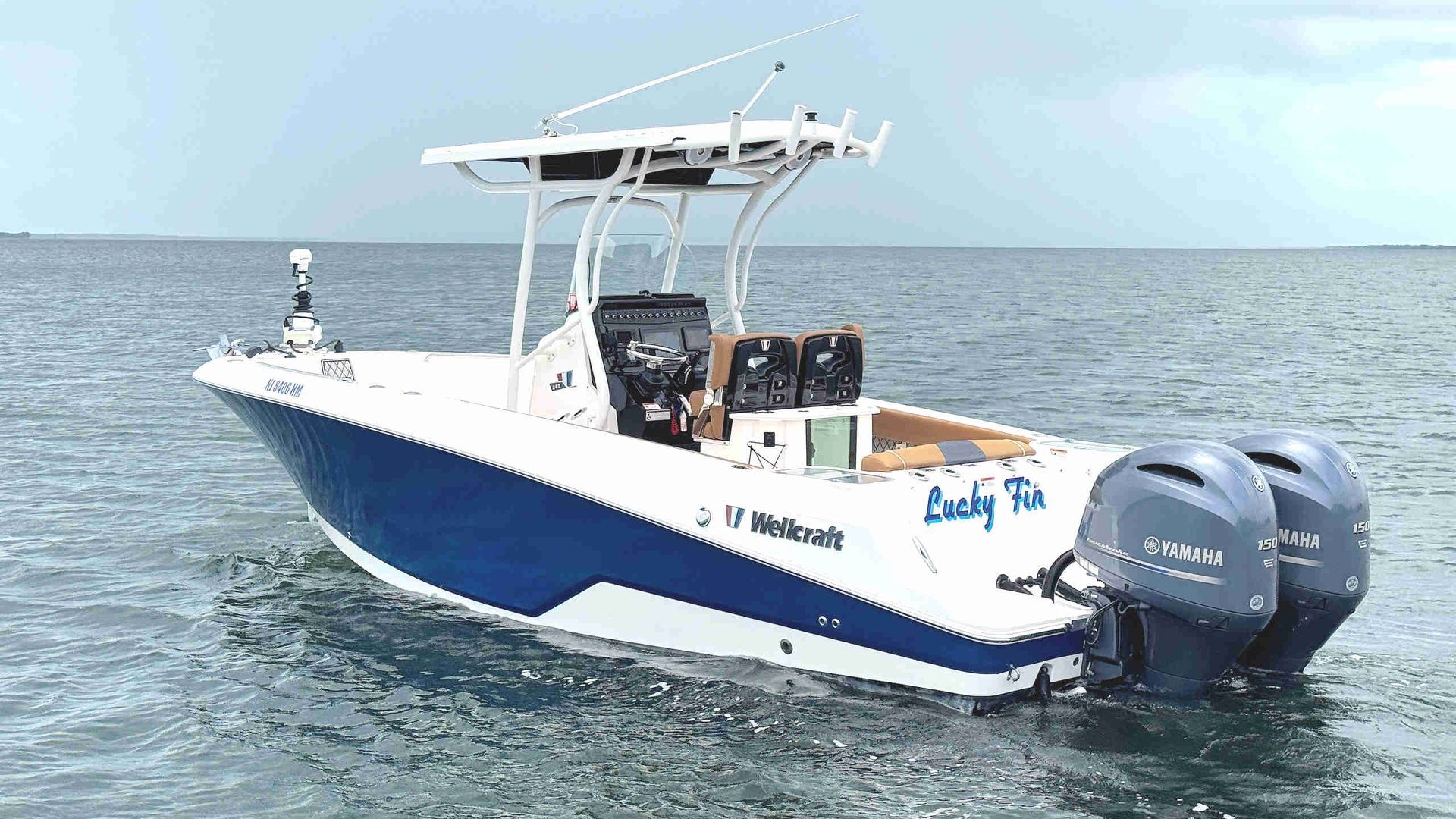 Wellcraft 242 Fisherman boat on calm water with twin outboard engines and canopy top