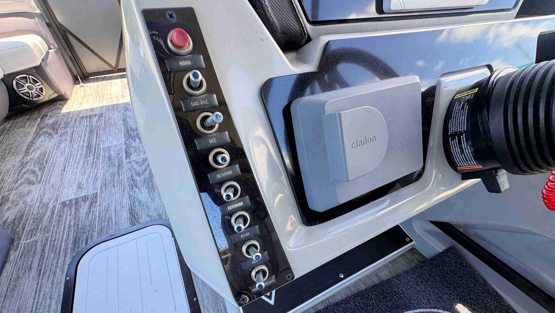 Close-up of a camera control panel with buttons and a mounted device on a helm.