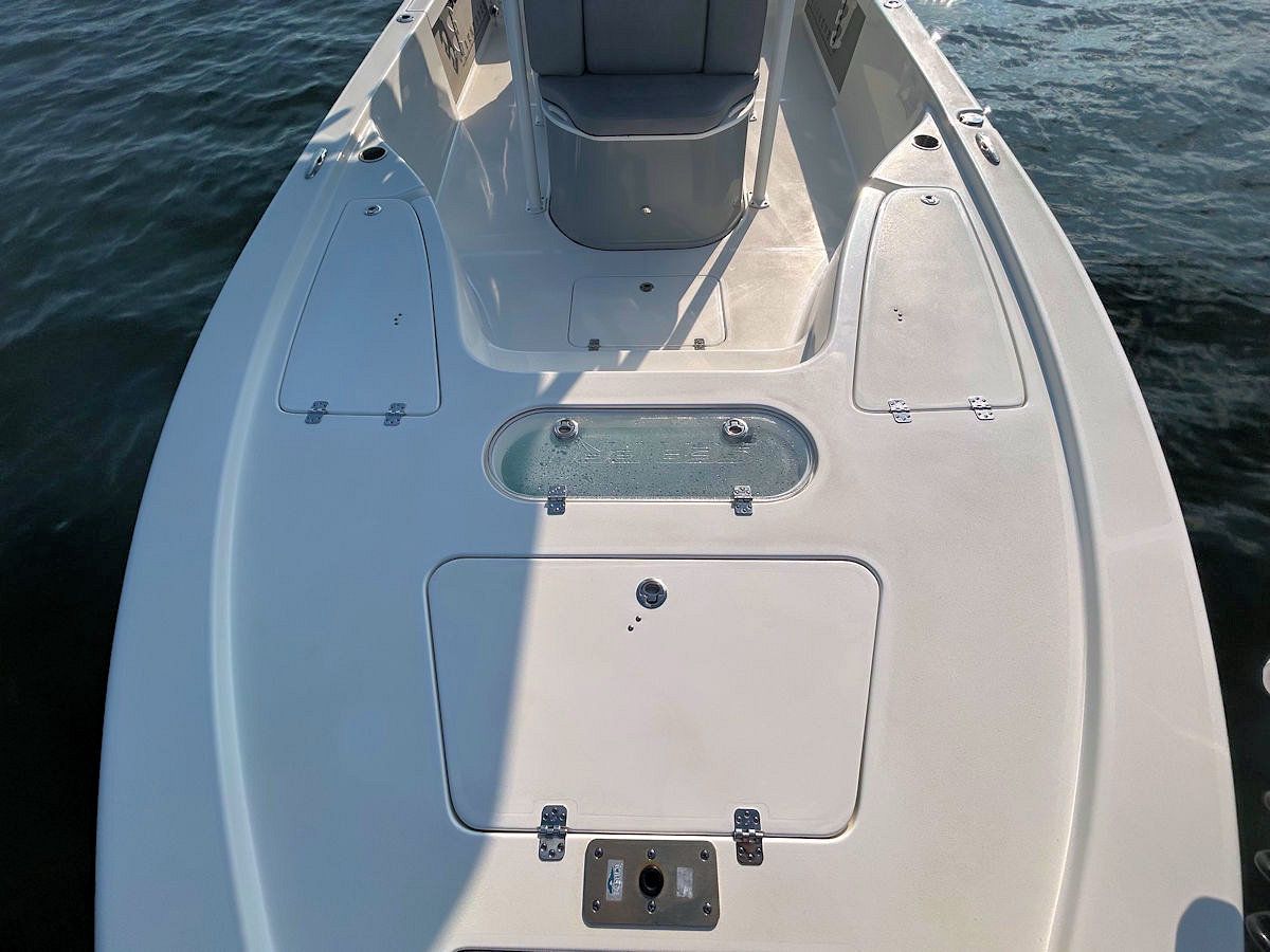 White fishing boat deck, open hatches, blue water background.