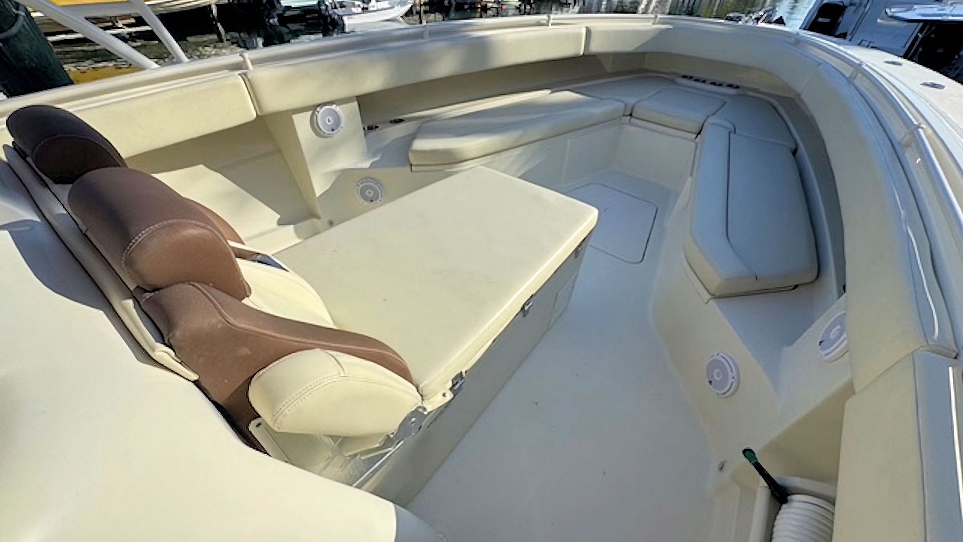 Boat bow with cream seating and tan cushions under a bright sunshade
