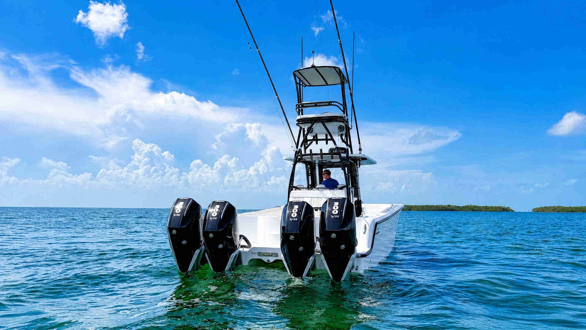 White catamaran center console fishing boat with quad outboard engines