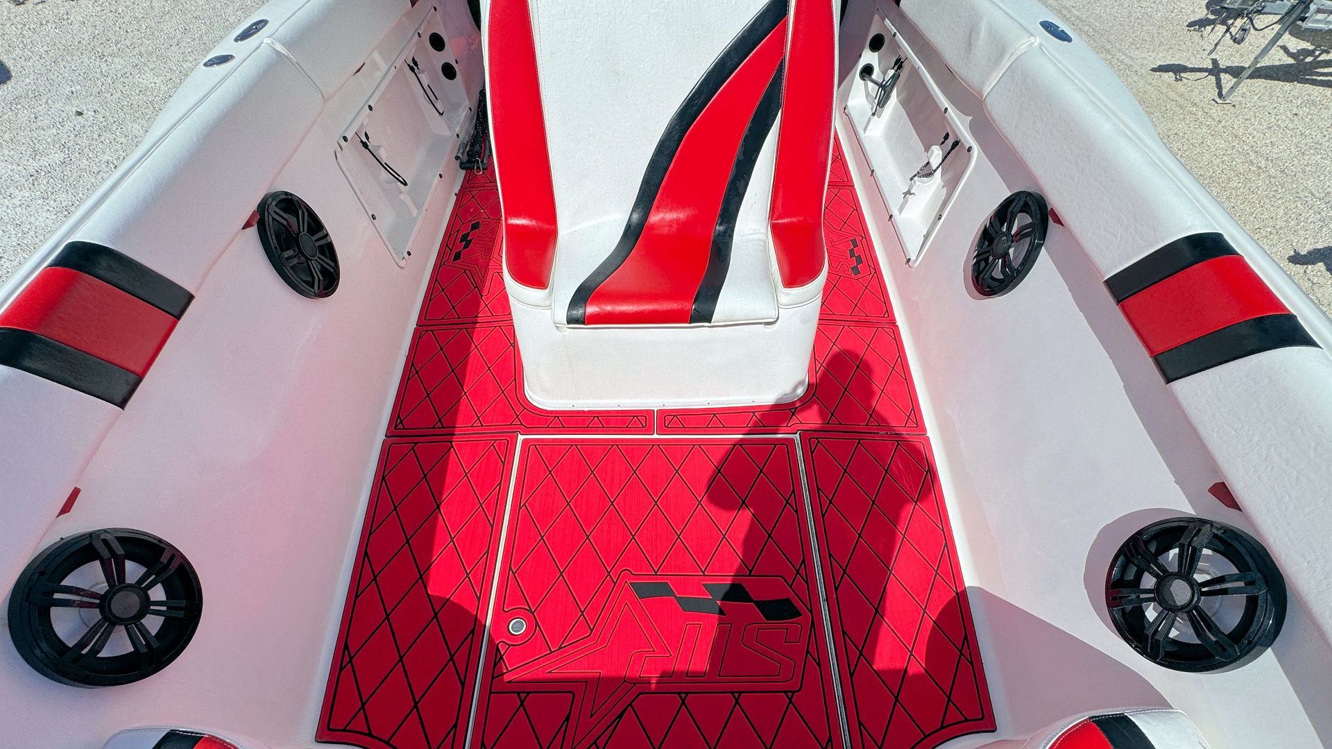 Red-and-white boat deck with two side seats and a narrow walkway leading forward