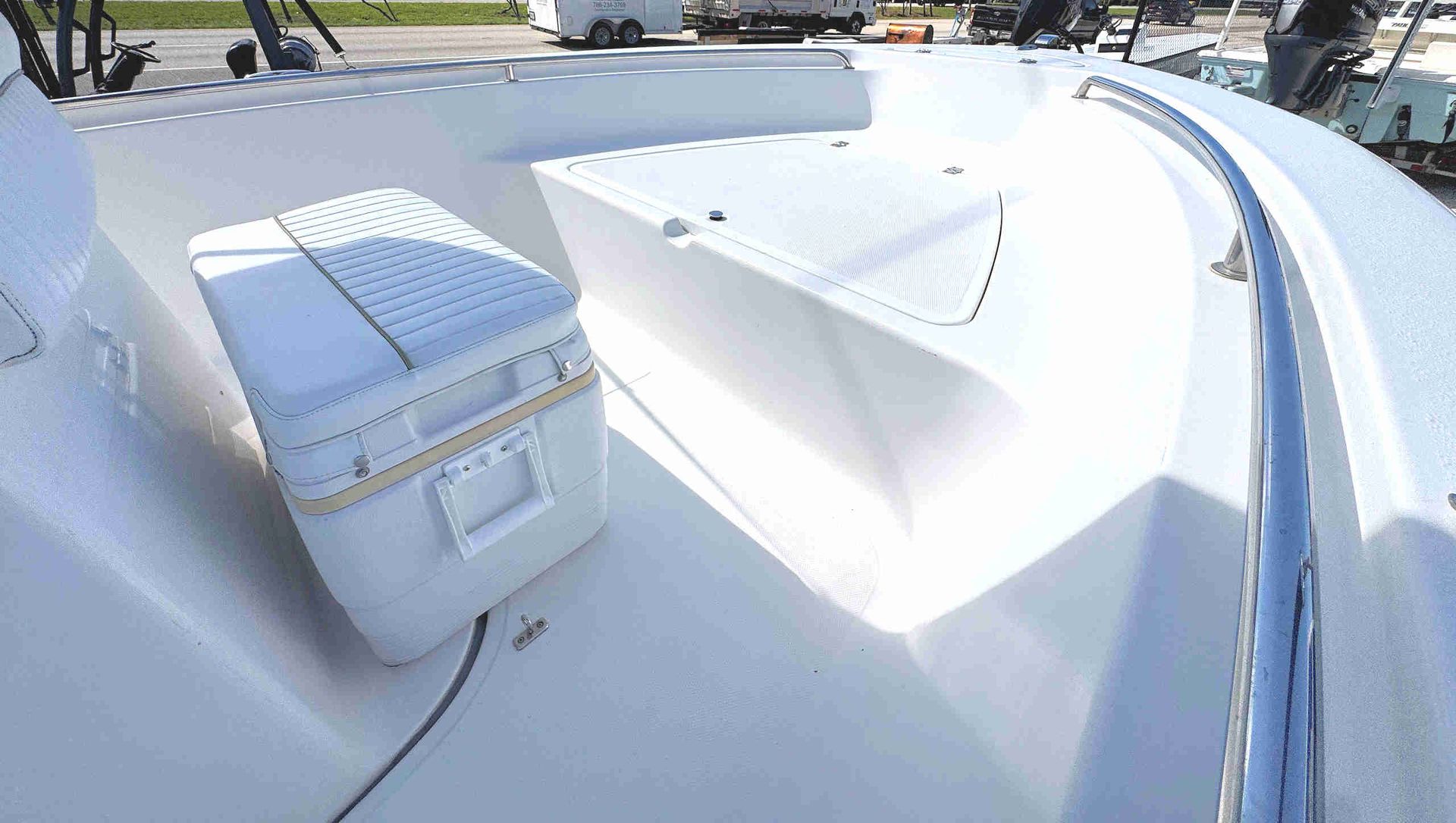 White boat deck with built-in seating and a cooler under bright sunlight