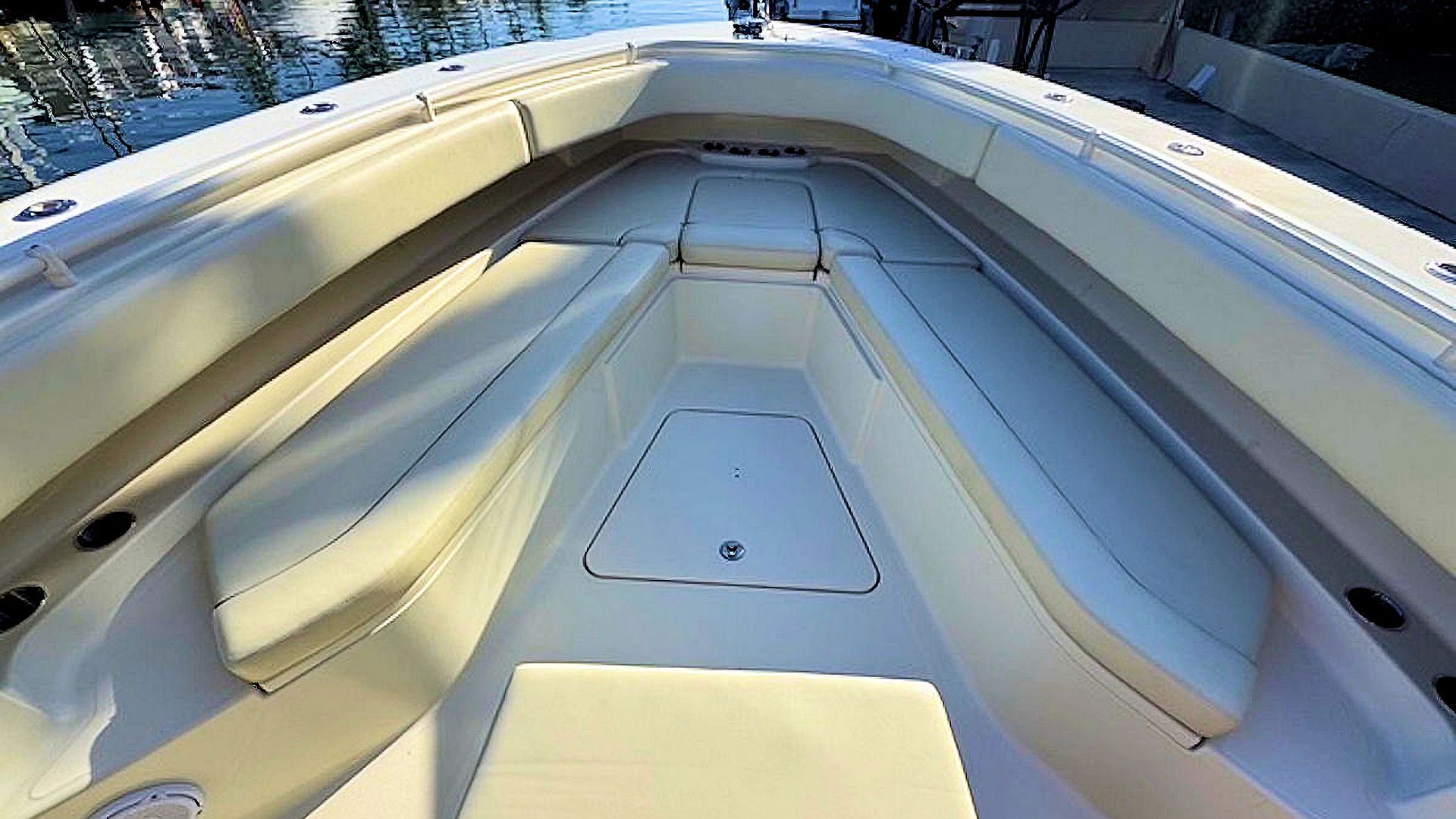 Bow seating viewed from the stern, with cushioned benches and blue water beyond.