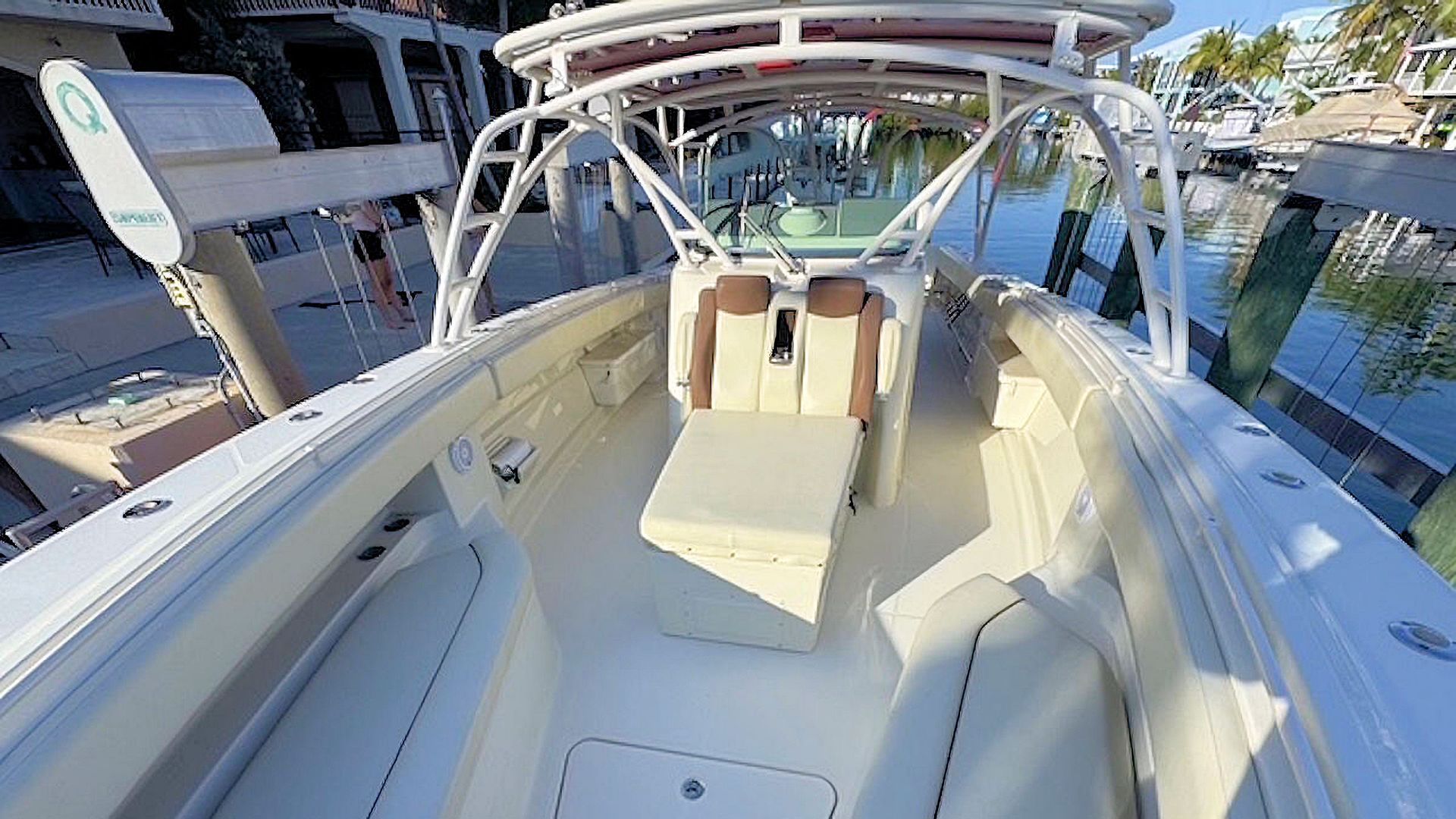 Center seat and canopy, docked on a sunny waterfront.
