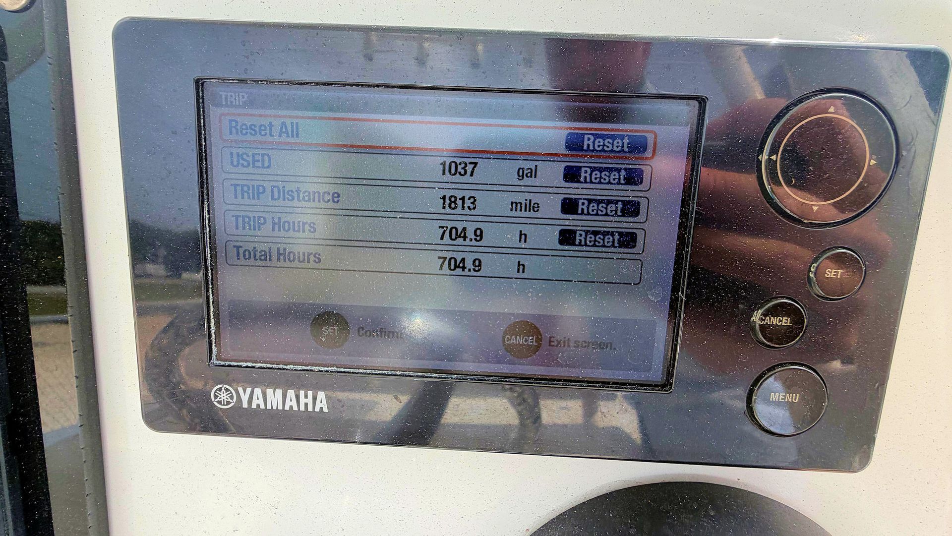 Close-up of a Yamaha control panel with a small display and silver buttons on a metallic surface