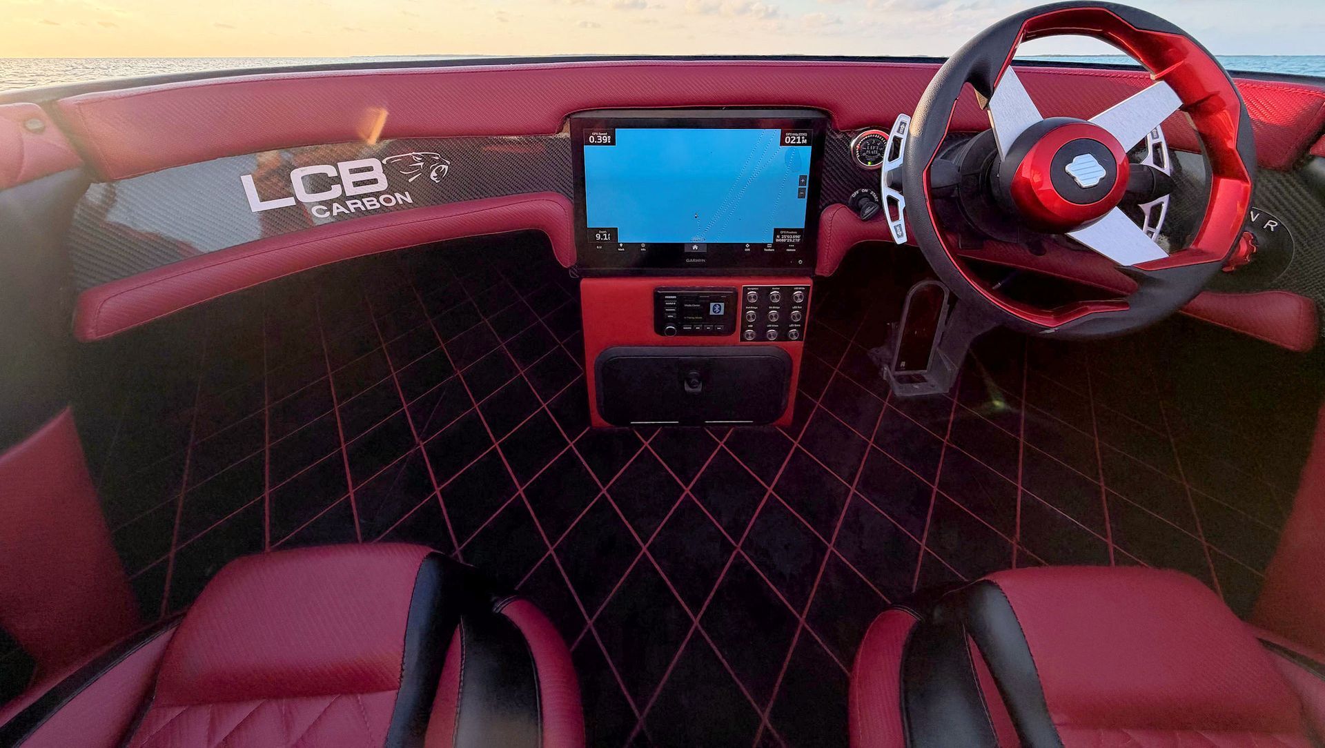 Helmstation with red-and-black seats, a red steering wheel, and a central display screen.