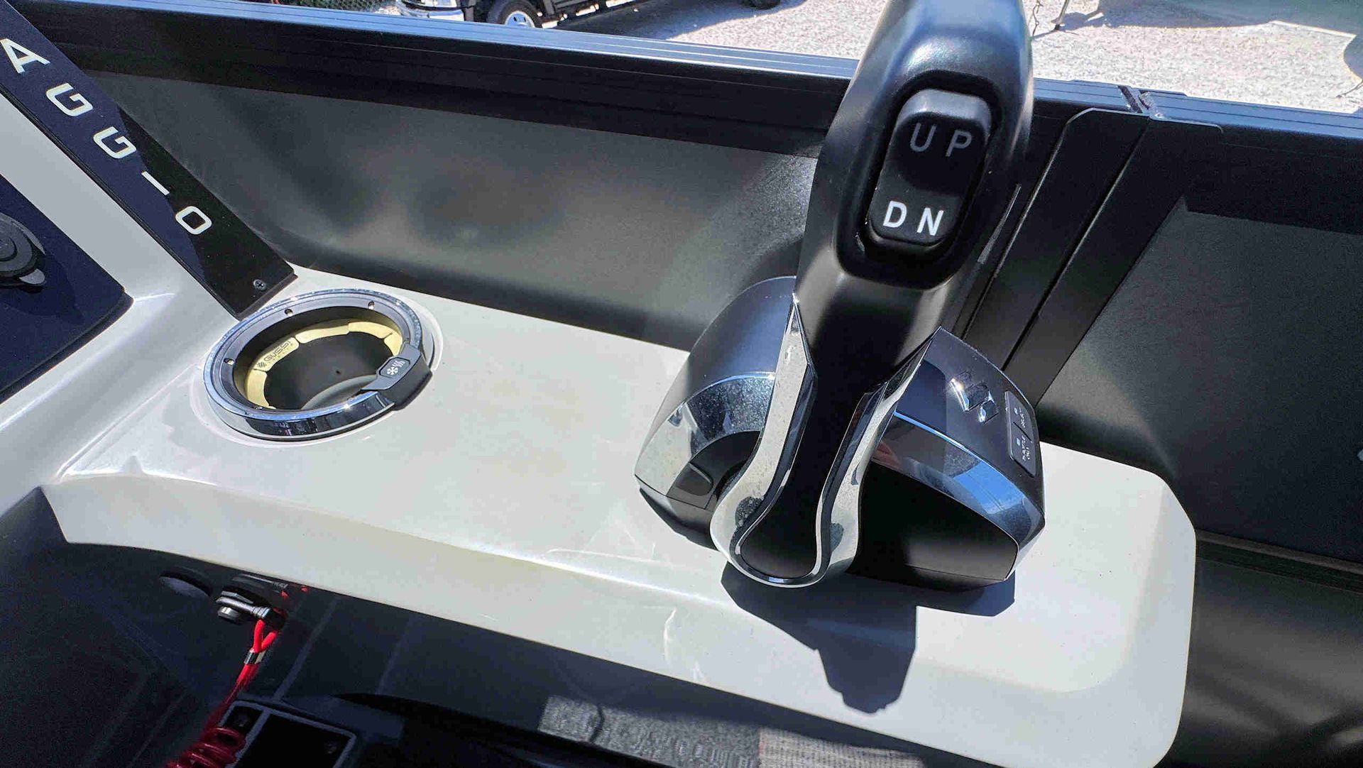 Boat helm with black throttle lever and cup holder on a light console