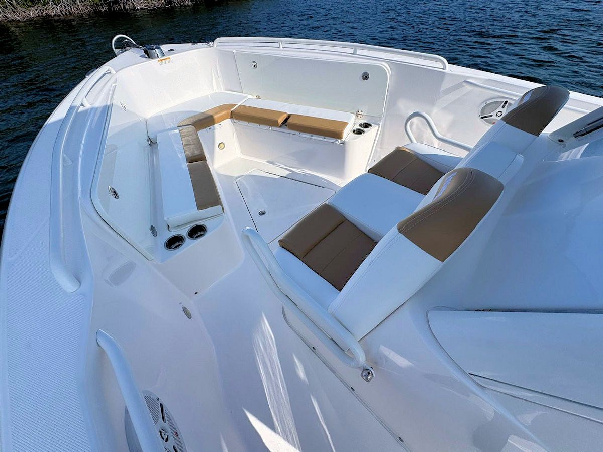White boat interior with tan and white seating, on the water.