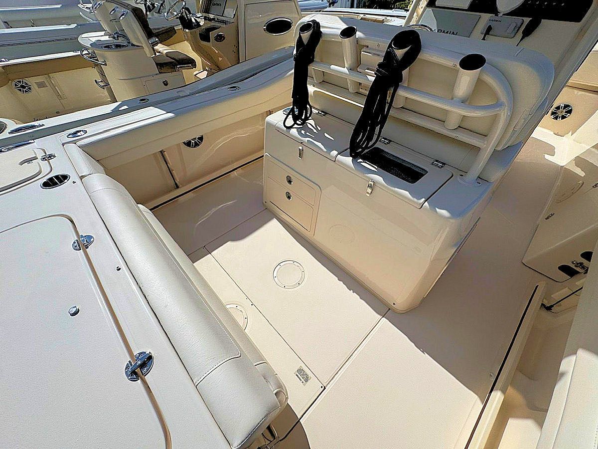 Interior of a boat with beige seats and deck. Features include storage and rod holders.