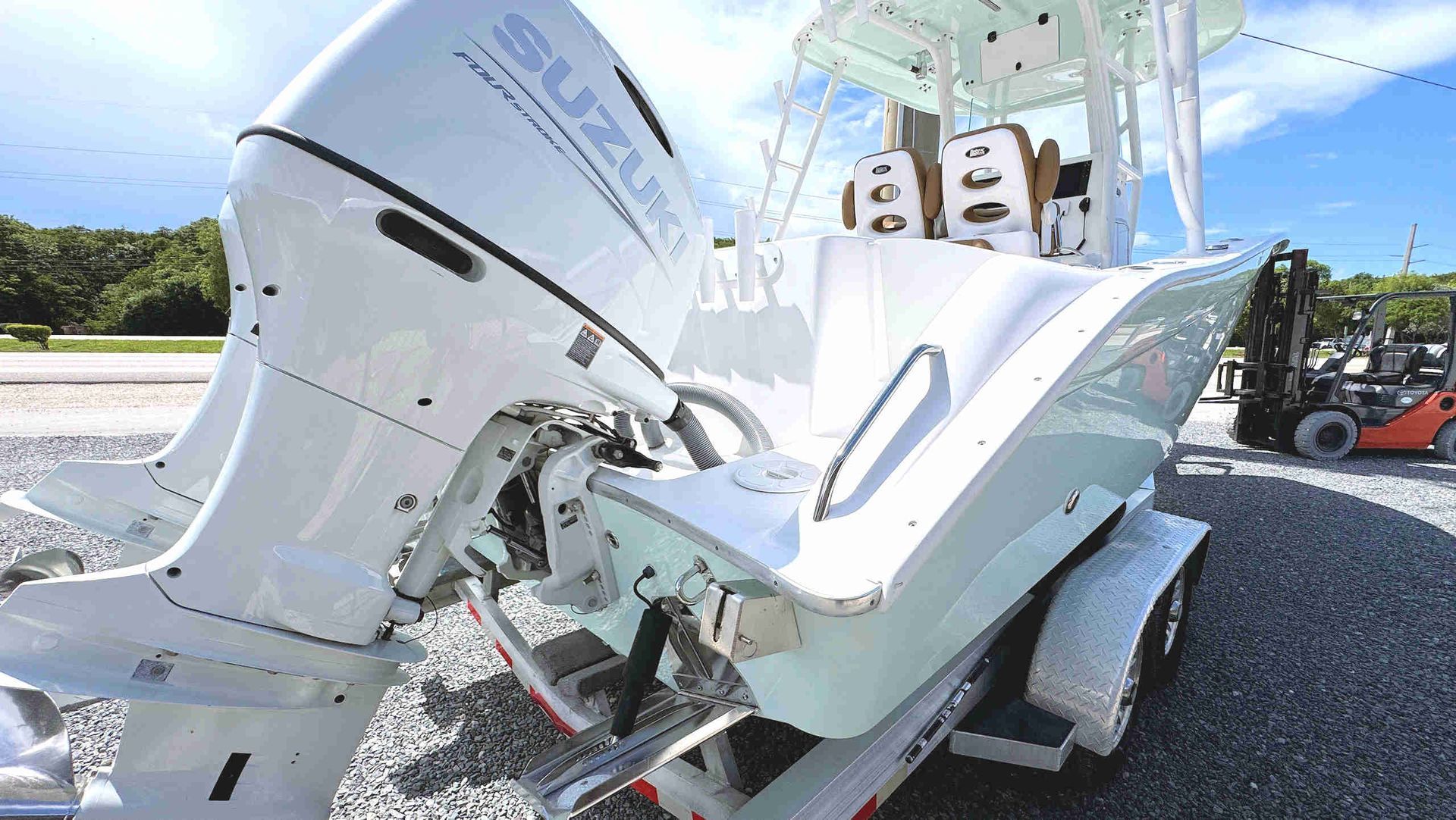 White boat with outboard motor on a trailer after a roadside collision