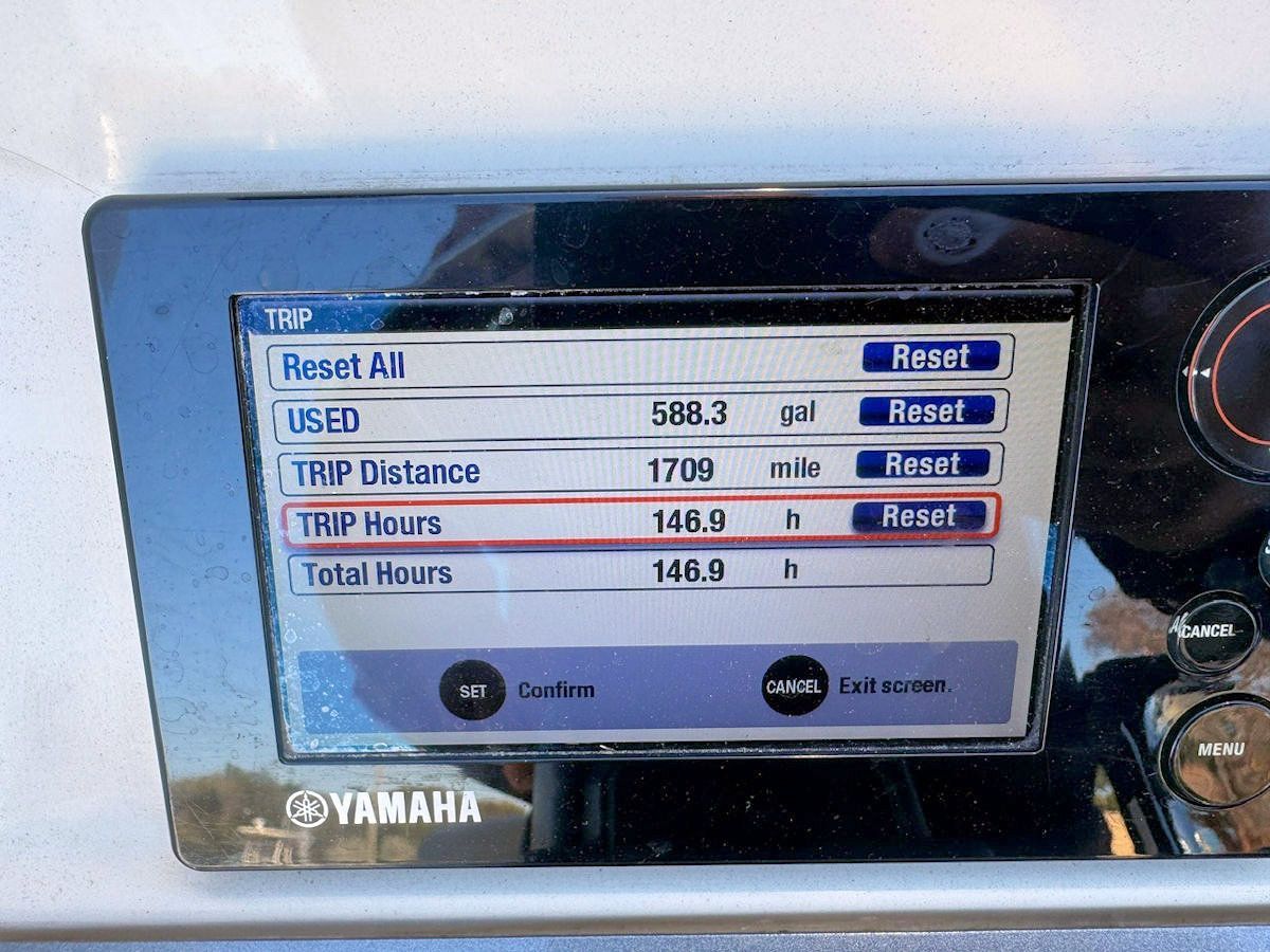 Yamaha boat display showing trip data: 148.9 hours and 1700 miles. Reset options visible.