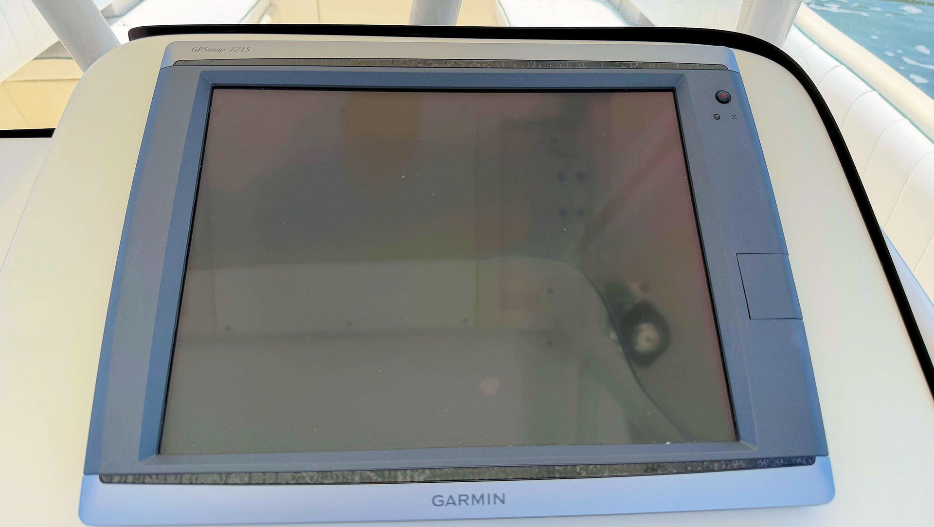 Blue Garmin marine GPS/chartplotter screen mounted on a boat console