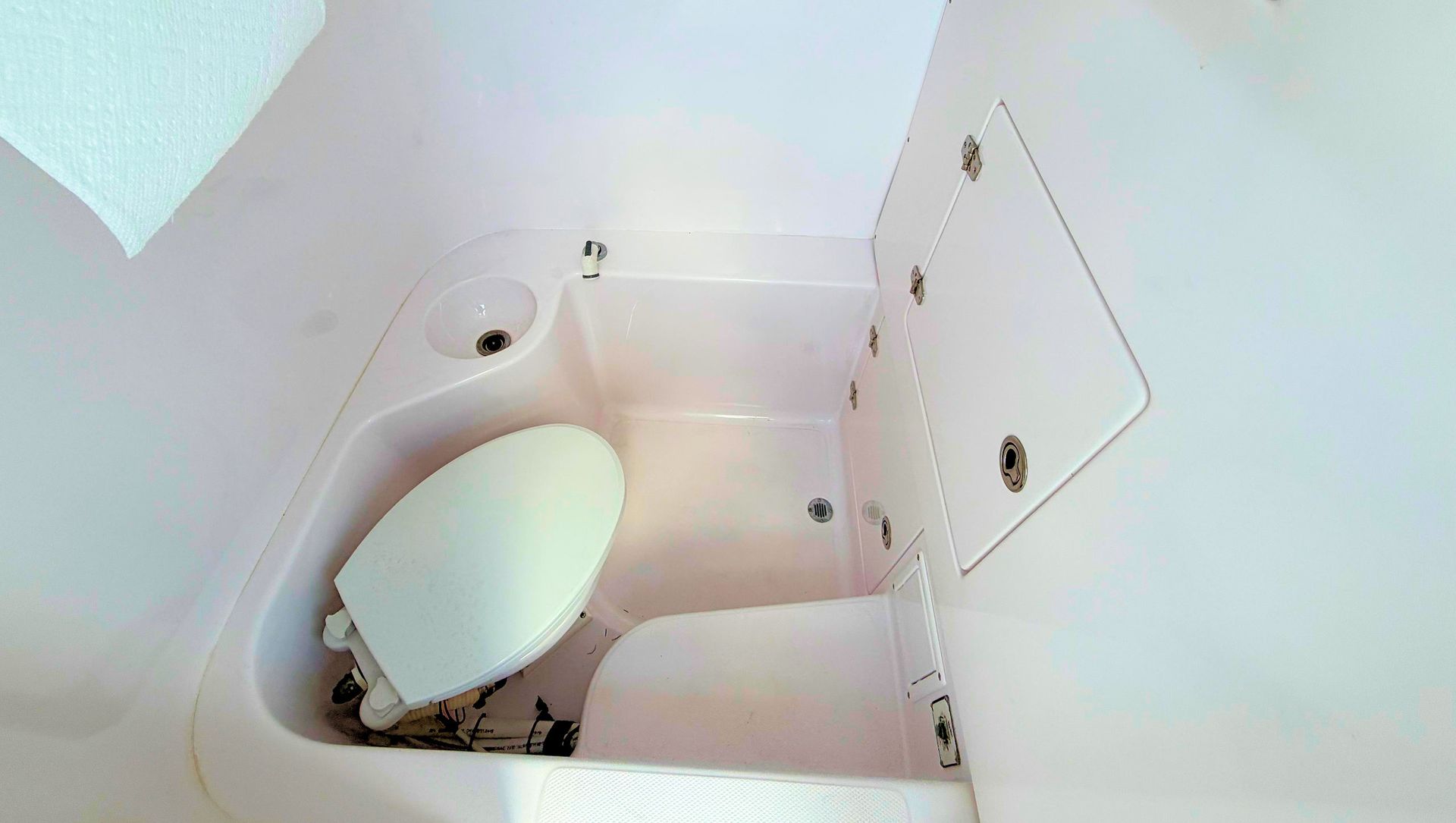 Small white bathroom with a toilet and shower compartment, viewed from above.