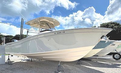 A white boat on a trailer, under a partly cloudy sky.