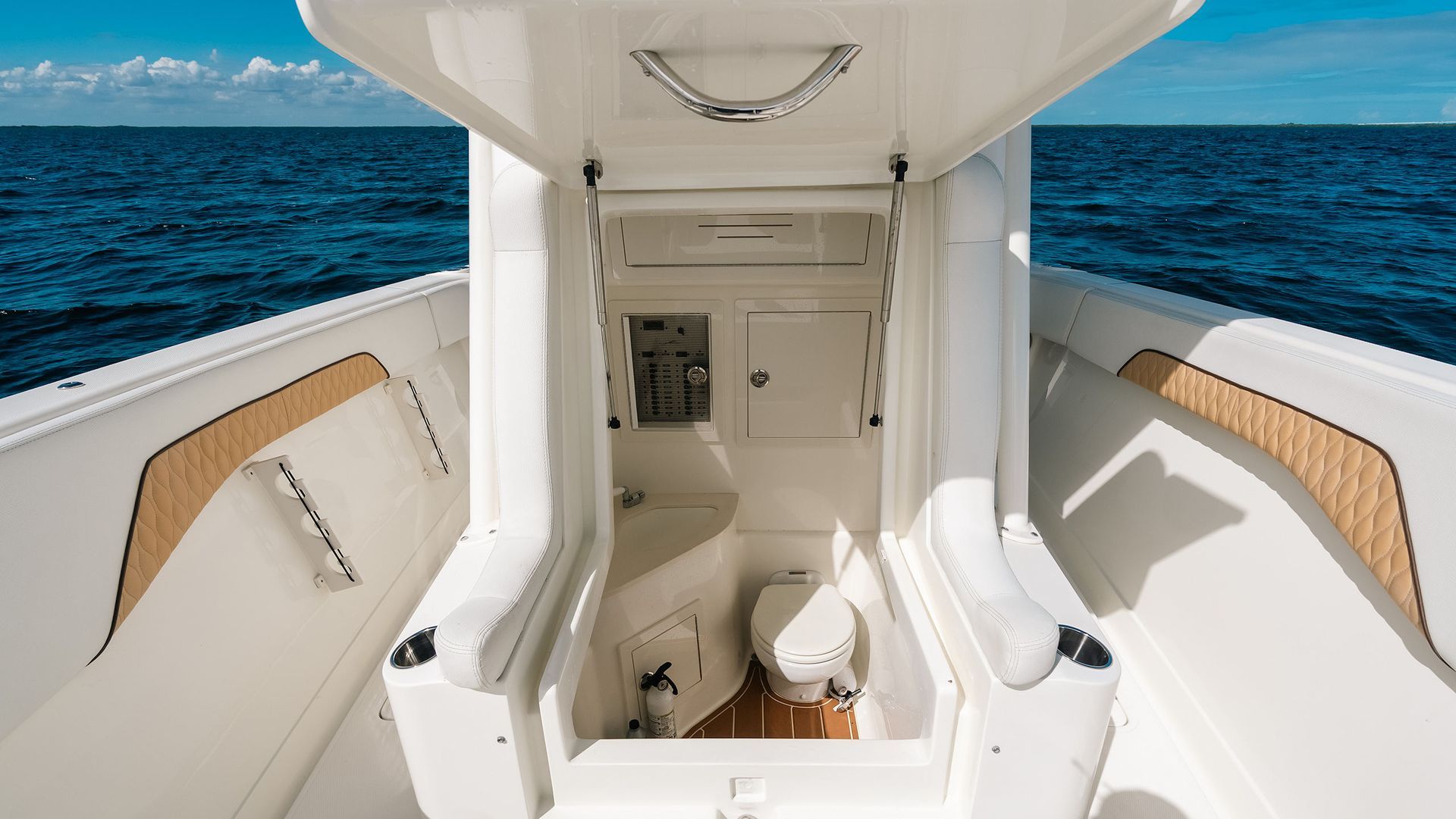 White boat center console head and storage entrance, with blue ocean visible on both sides.