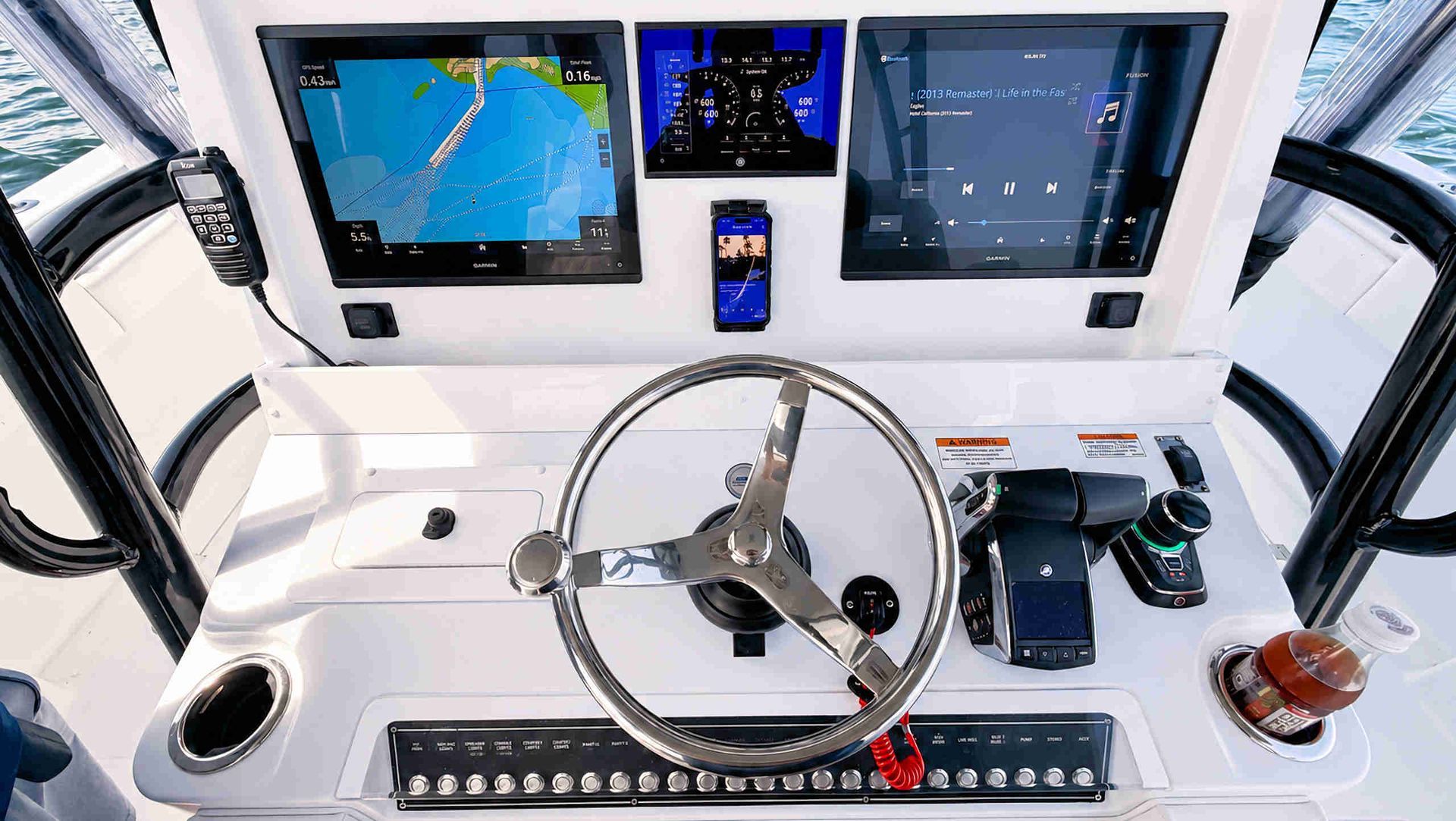 Modern boat helm with steering wheel, navigation screens, throttle controls, and white dashboard