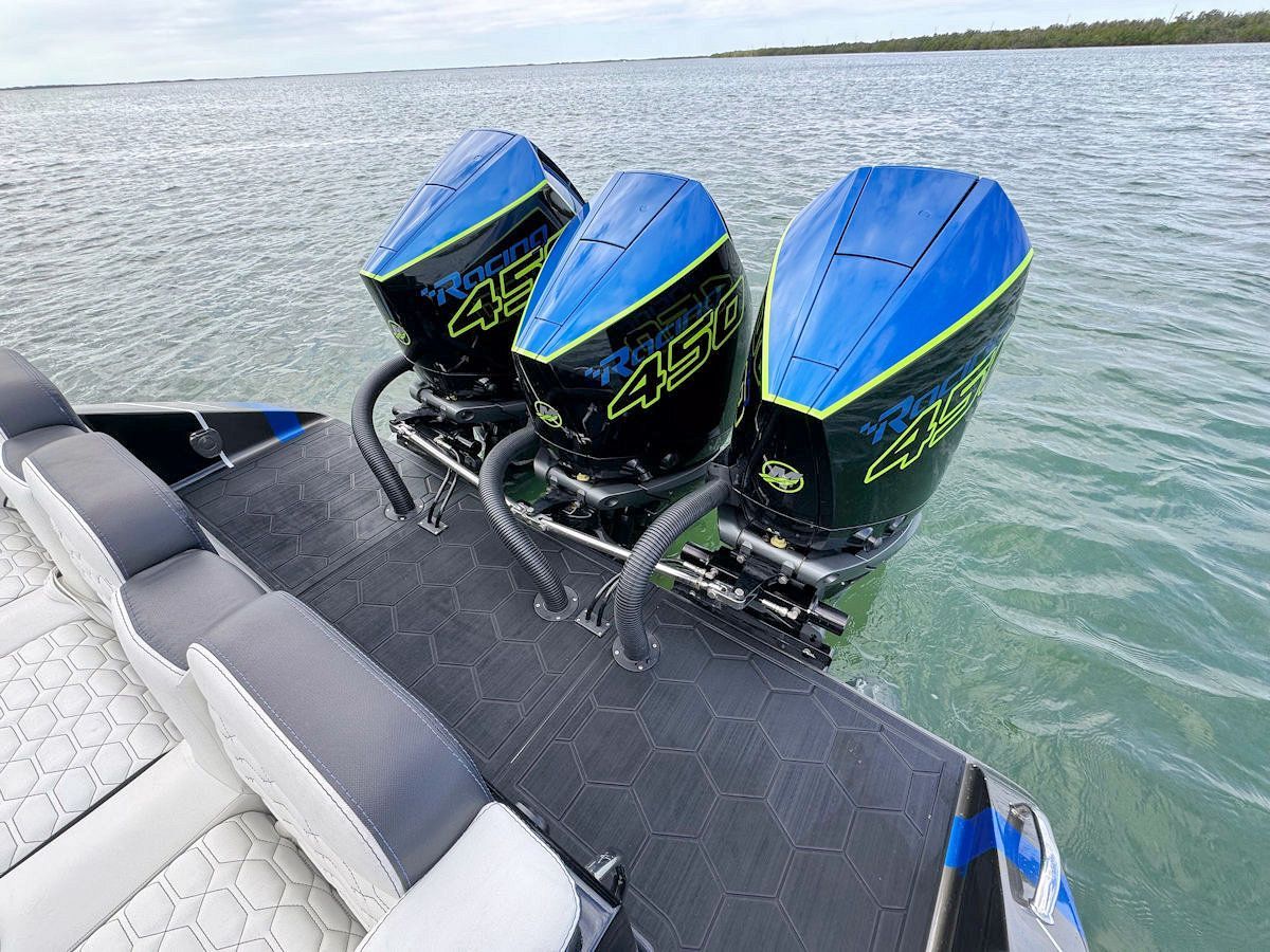 Three blue and black outboard boat motors mounted on the back of a boat.