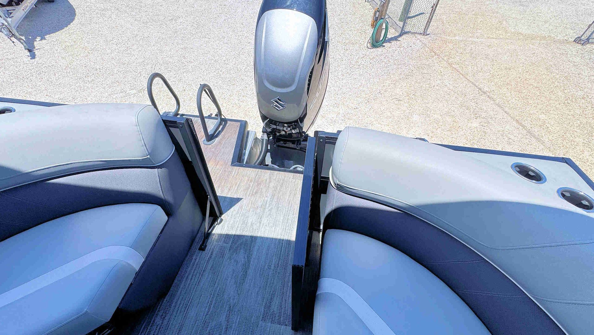 Boat deck seats facing an outboard motor on clear water