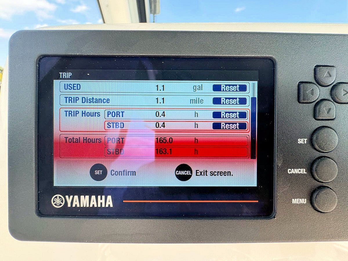 Yamaha boat display showing trip data: distance, hours, total hours. Screen lit, black and blue display.