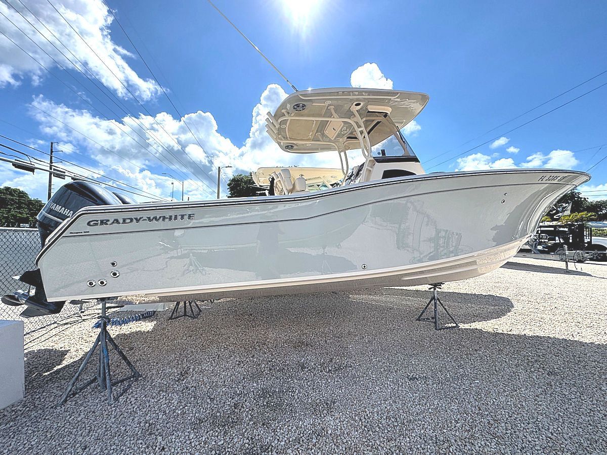 White Grady-White boat on stands in a sunny lot, with a blue sky background.