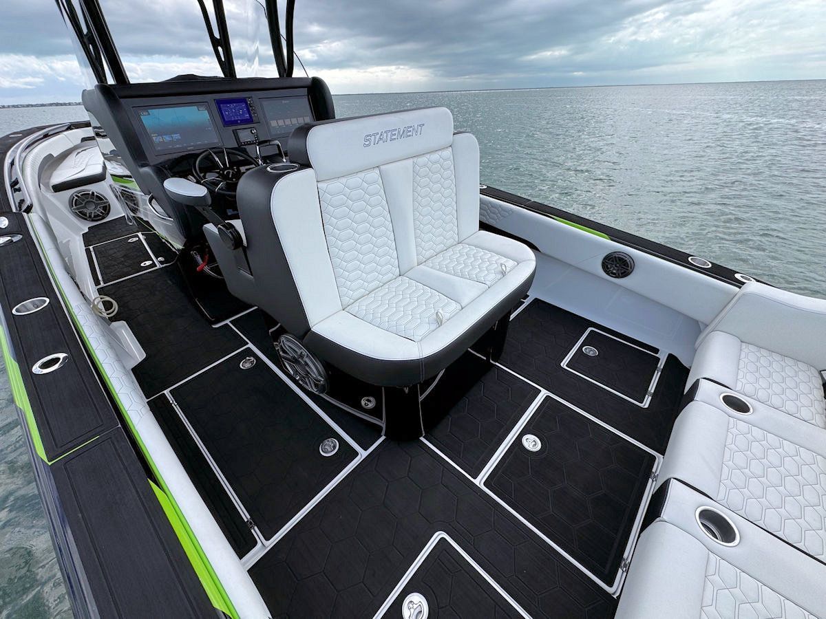 Motorboat cockpit with black and white seats and flooring on the water.
