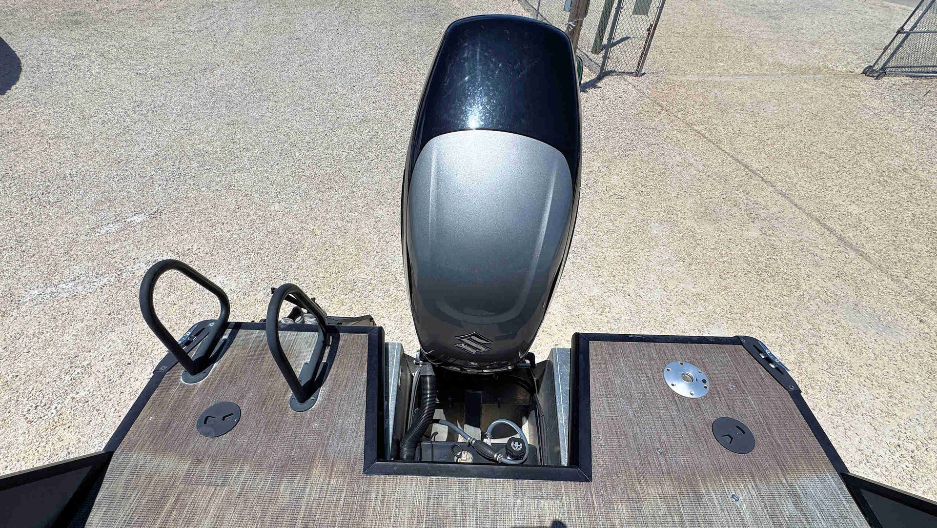 Outboard motor mounted on the stern of a Tritoon boat.