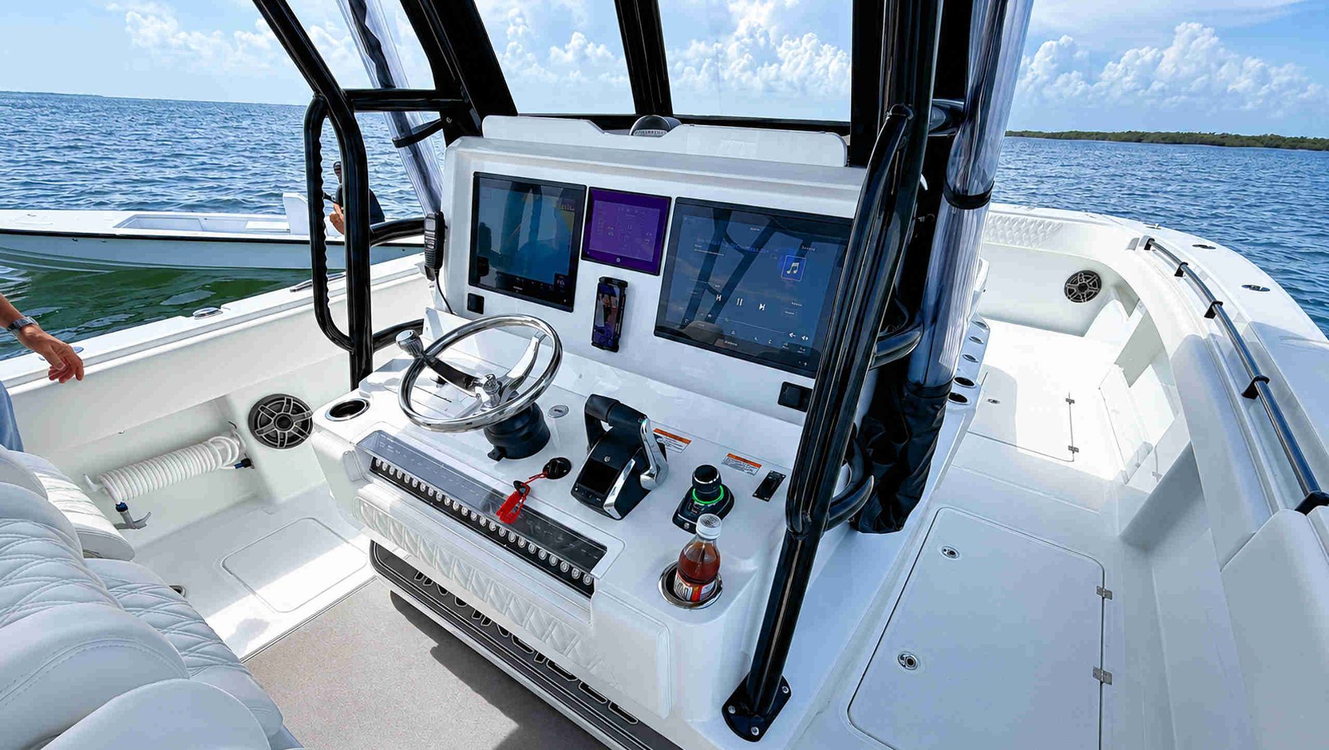 Boat helm with steering wheel, control panels, and ocean view through the windshield