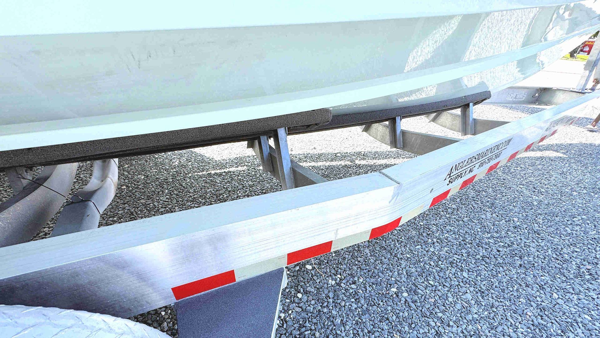 Close-up of trailer side with red reflectors and a gravel lot beneath it