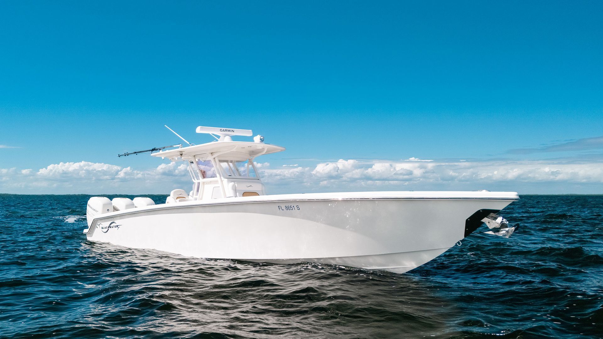 White center-console motorboat on blue ocean under a clear sky