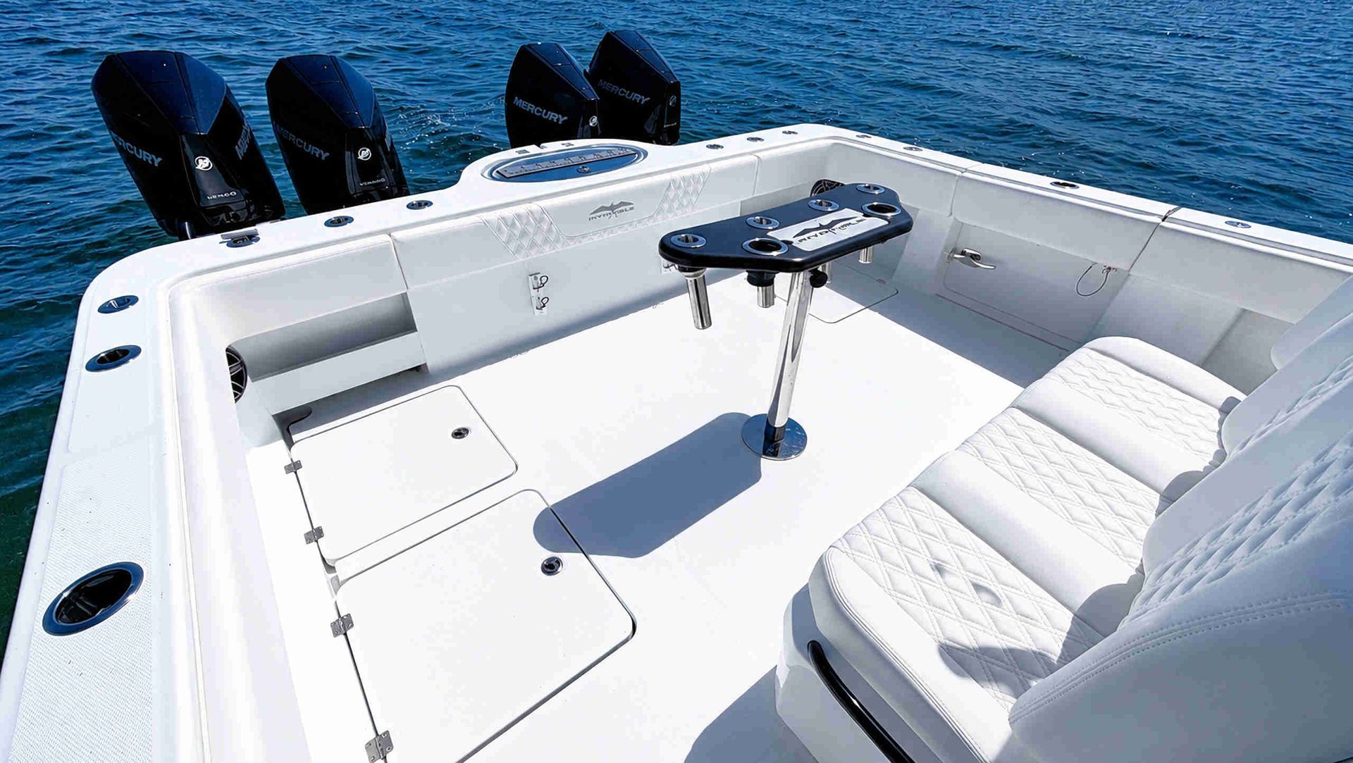 White catamaran center console fishing boat deck with seating, fishing rods, and ocean view