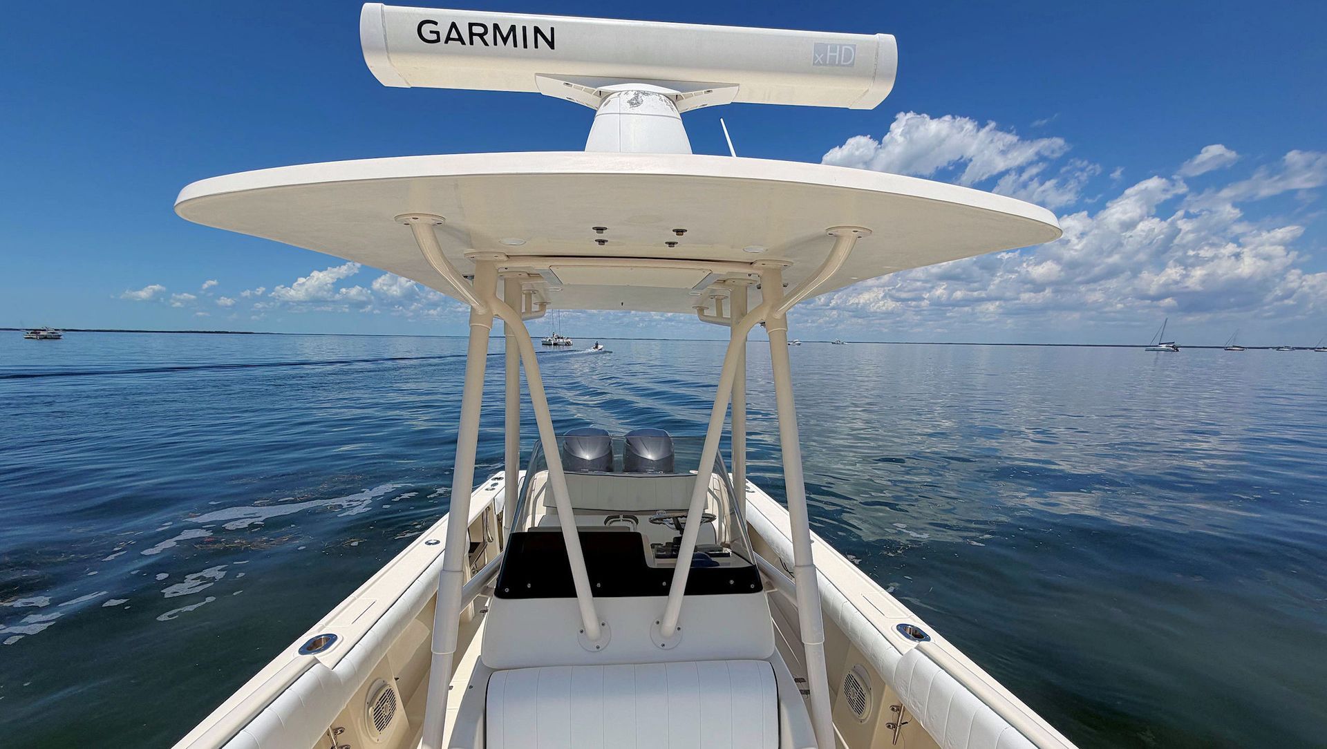 View from the bow looking aft at t-top under a blue sky, with a Garmin radar mounted overhead.