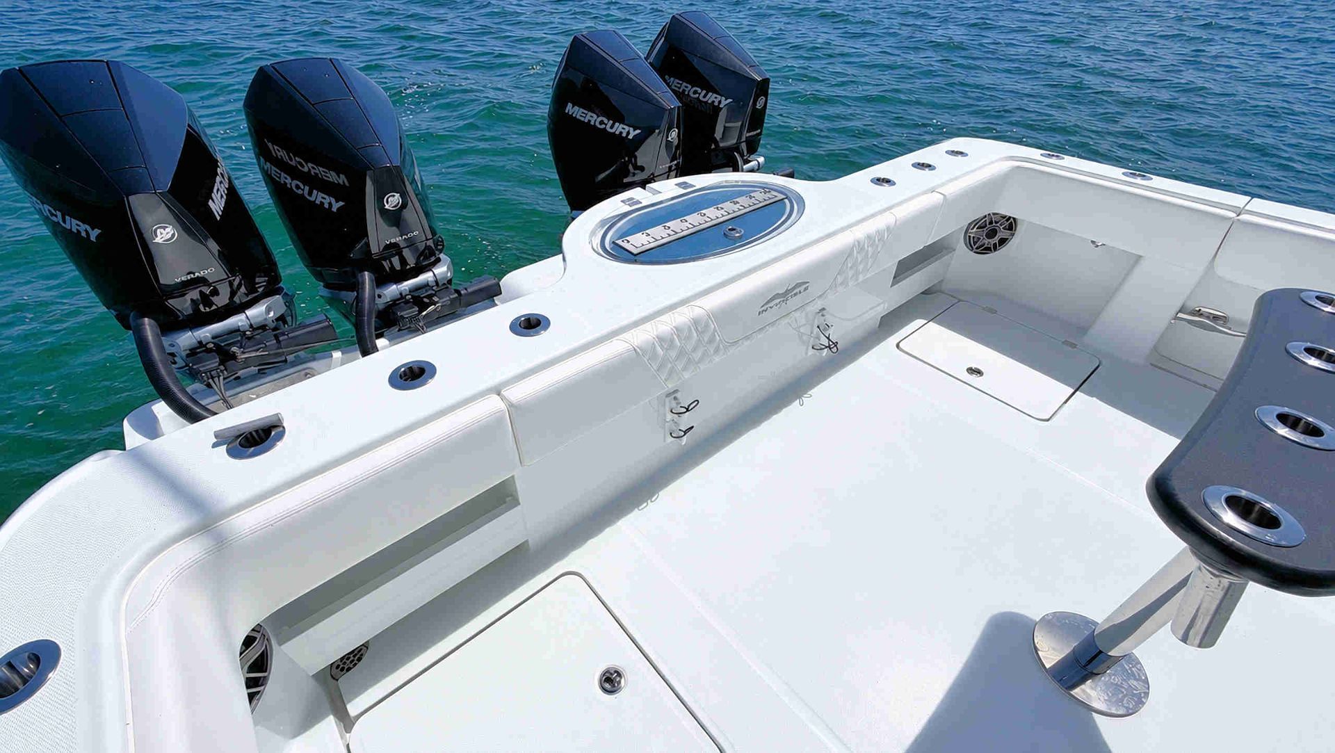 White catamaran center console fishing boat cockpit with four black outboard motors.