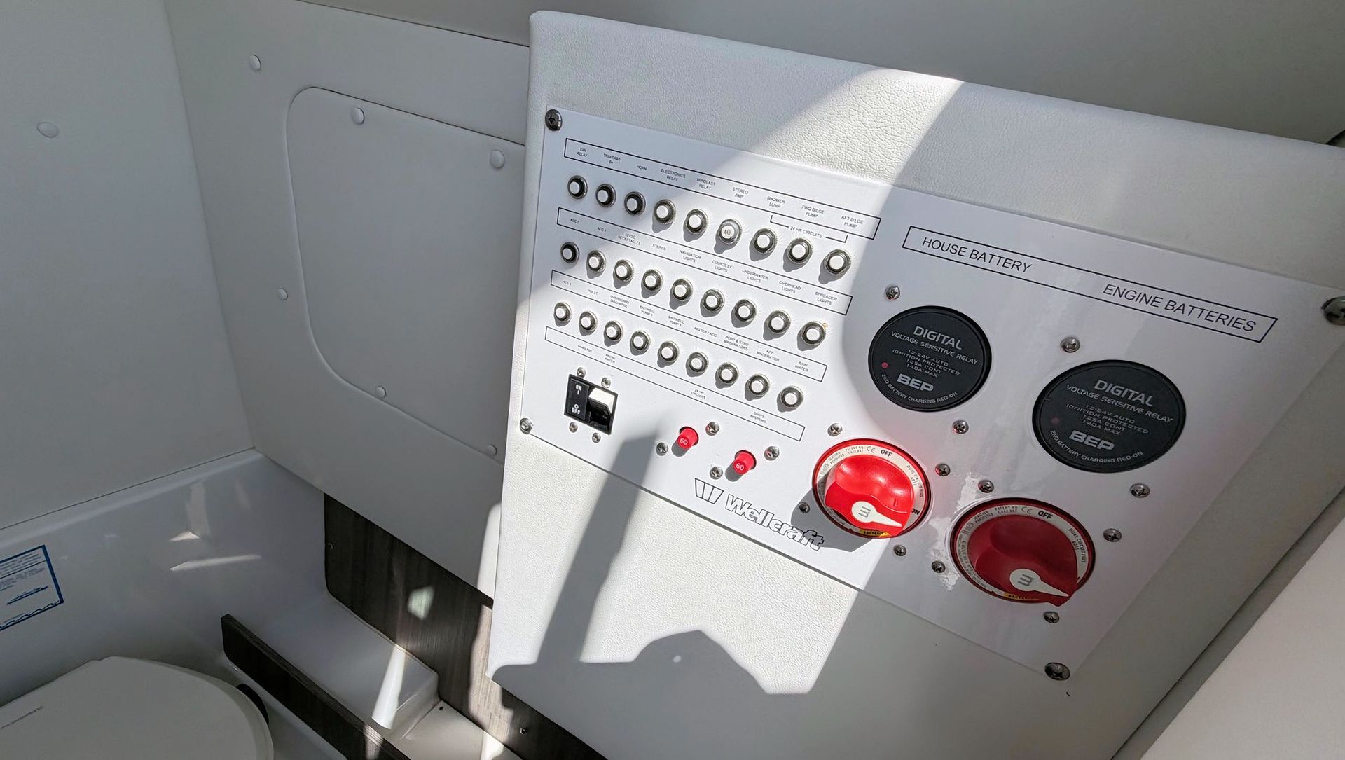 Control panel with switches and gauges, including red emergency knobs in a bright industrial interior