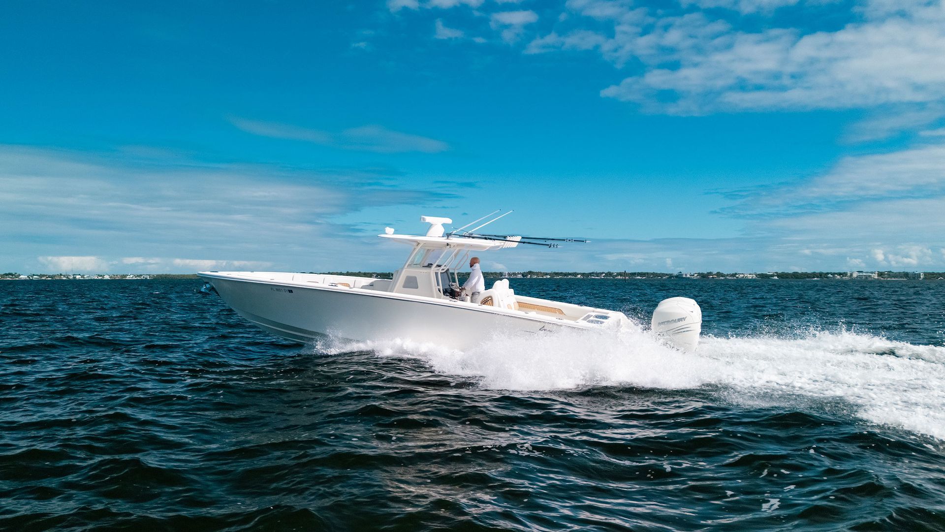 White speedboat racing across choppy blue water under a bright sky.