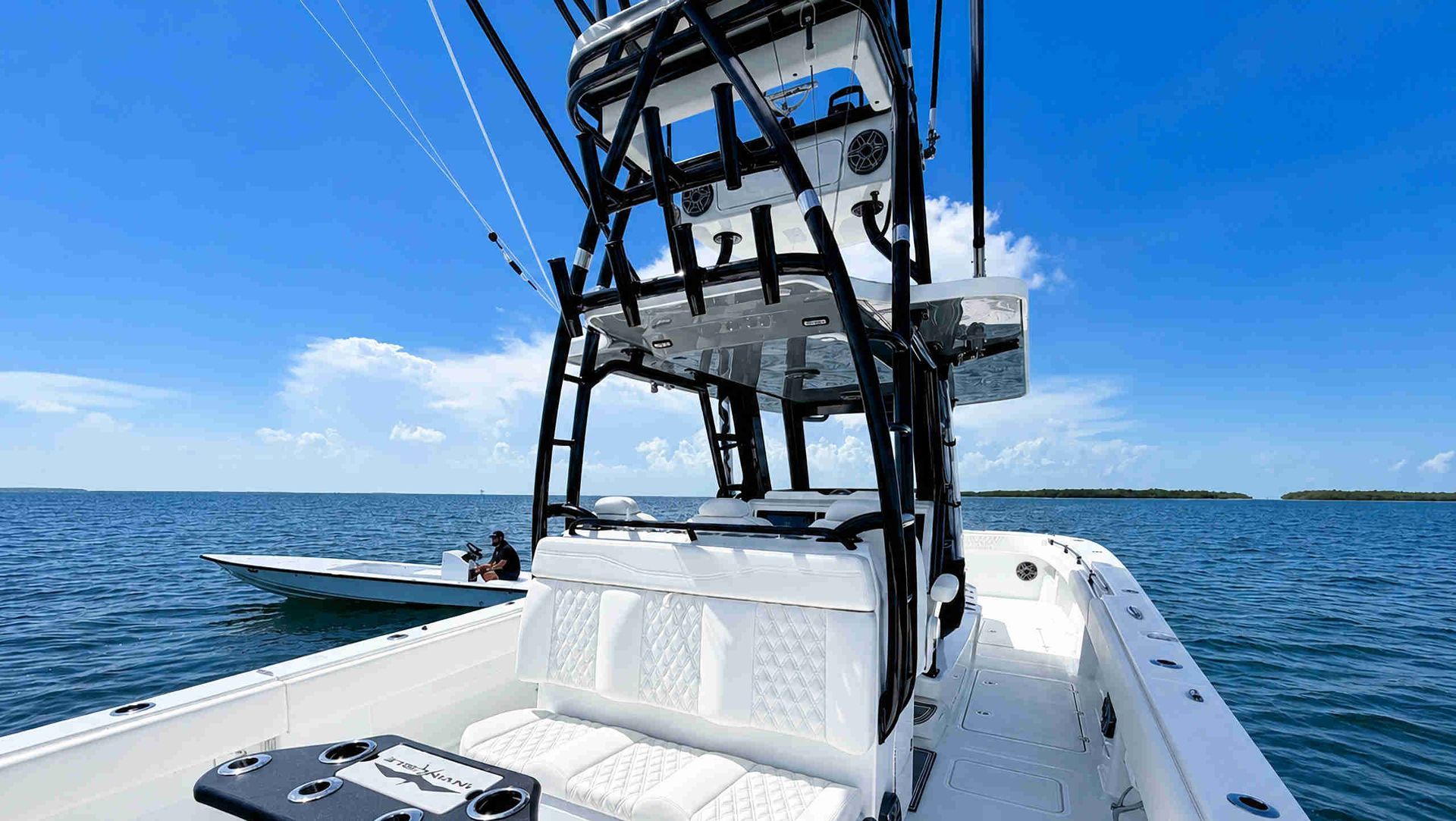 Boat cockpit with a black tower on calm blue water under a clear sky