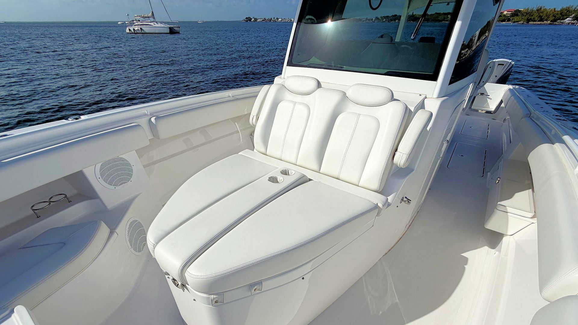 White cushioned seating in front of center console with blue ocean in the background