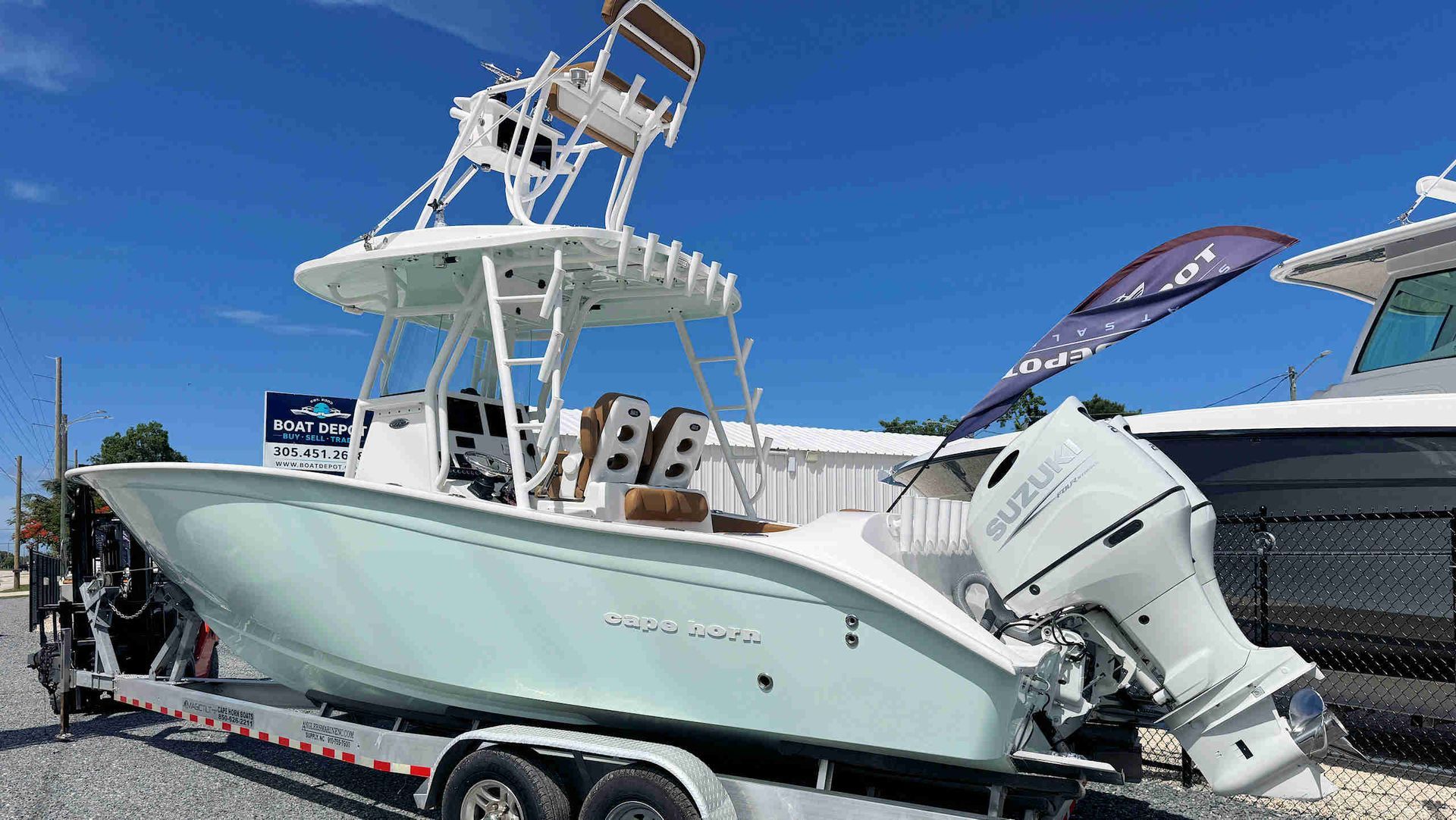 Light green Cape Horn center-console boat on a trailer at a marina under a clear blue sky