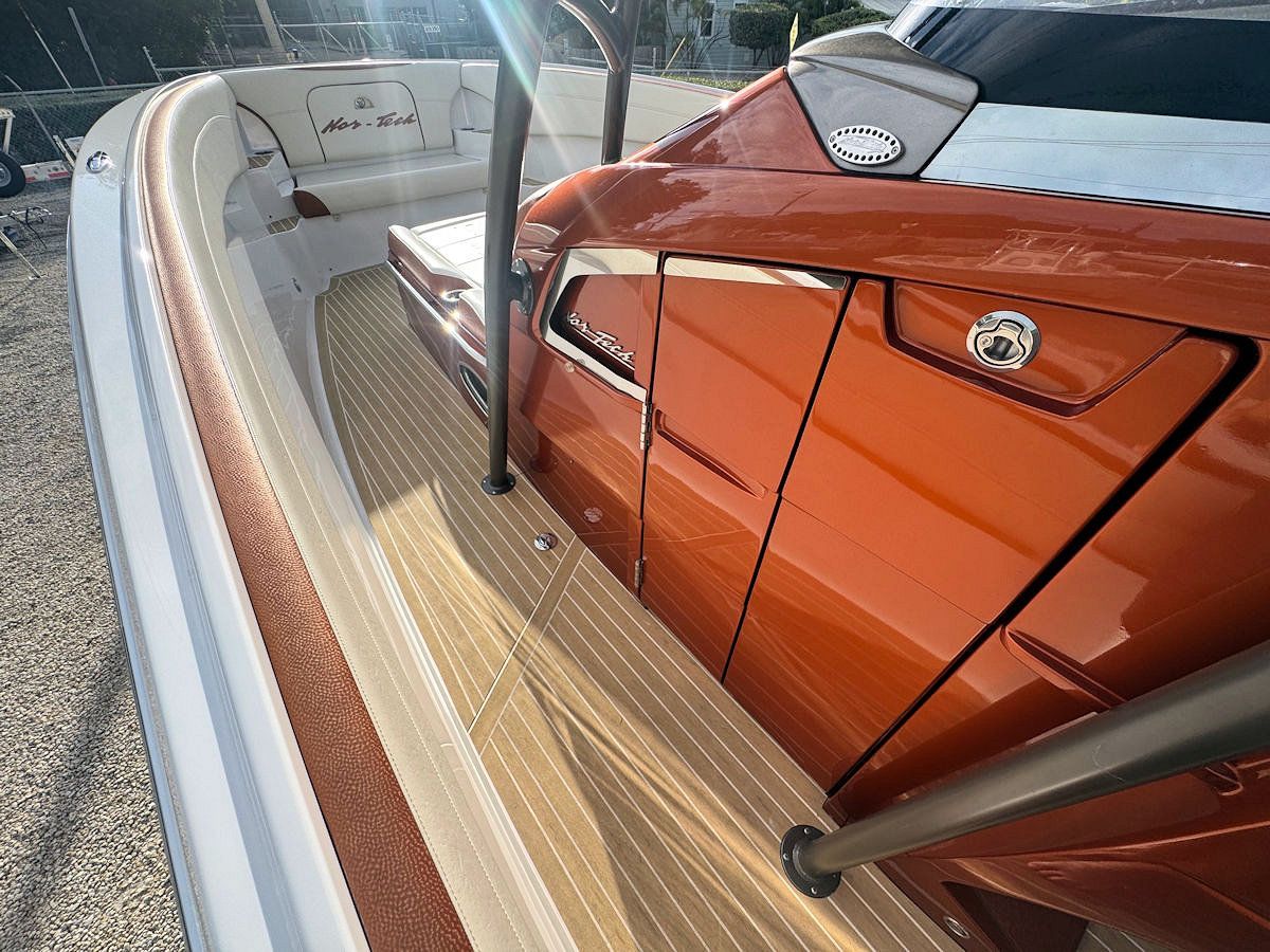 Orange and white speedboat with wooden decking, close-up view.