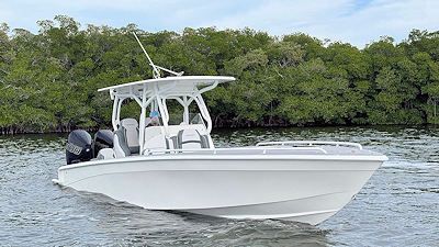 White motorboat on water with trees in the background.