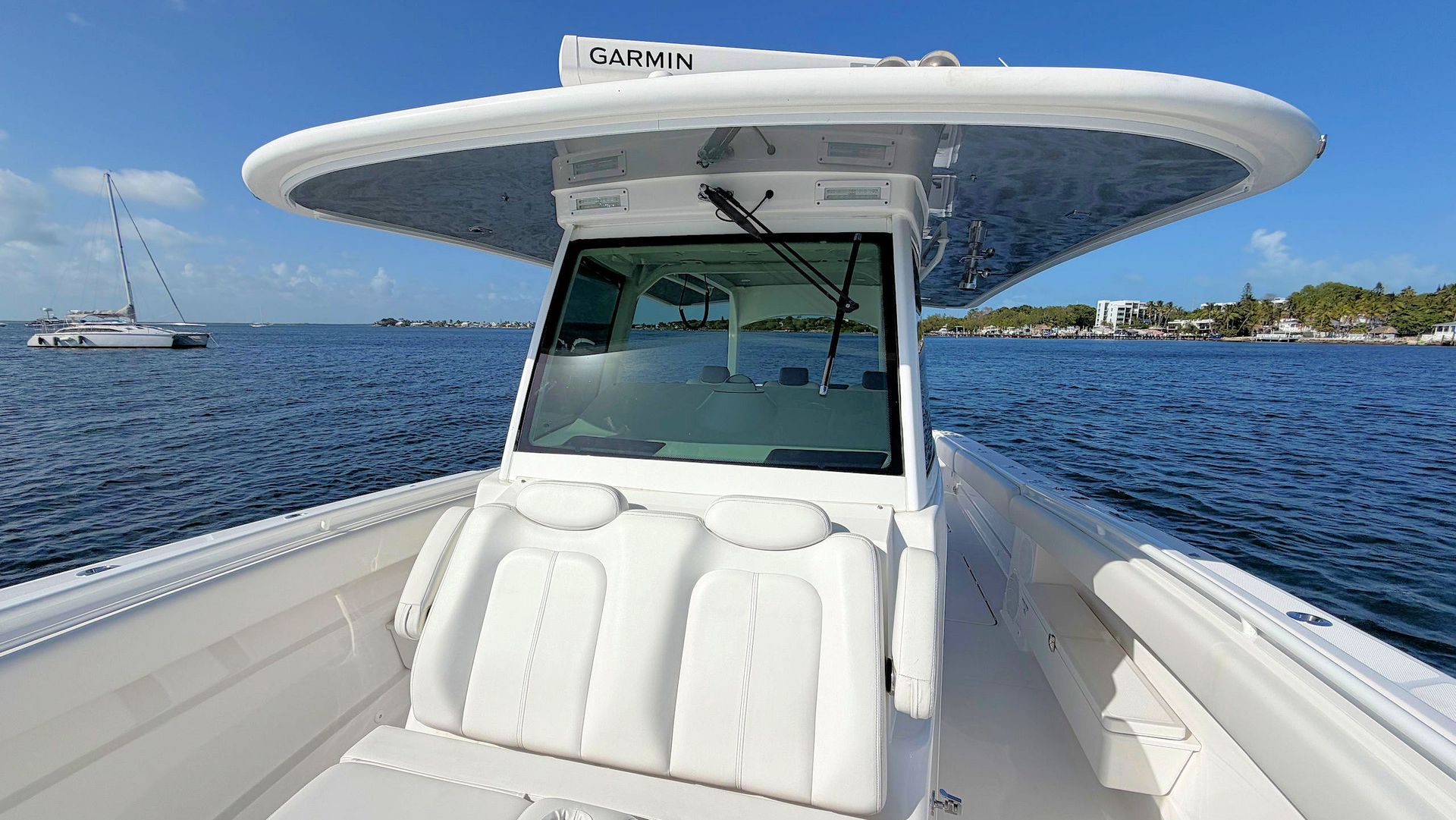 Front view of a white center-console boat on blue water under a clear sky