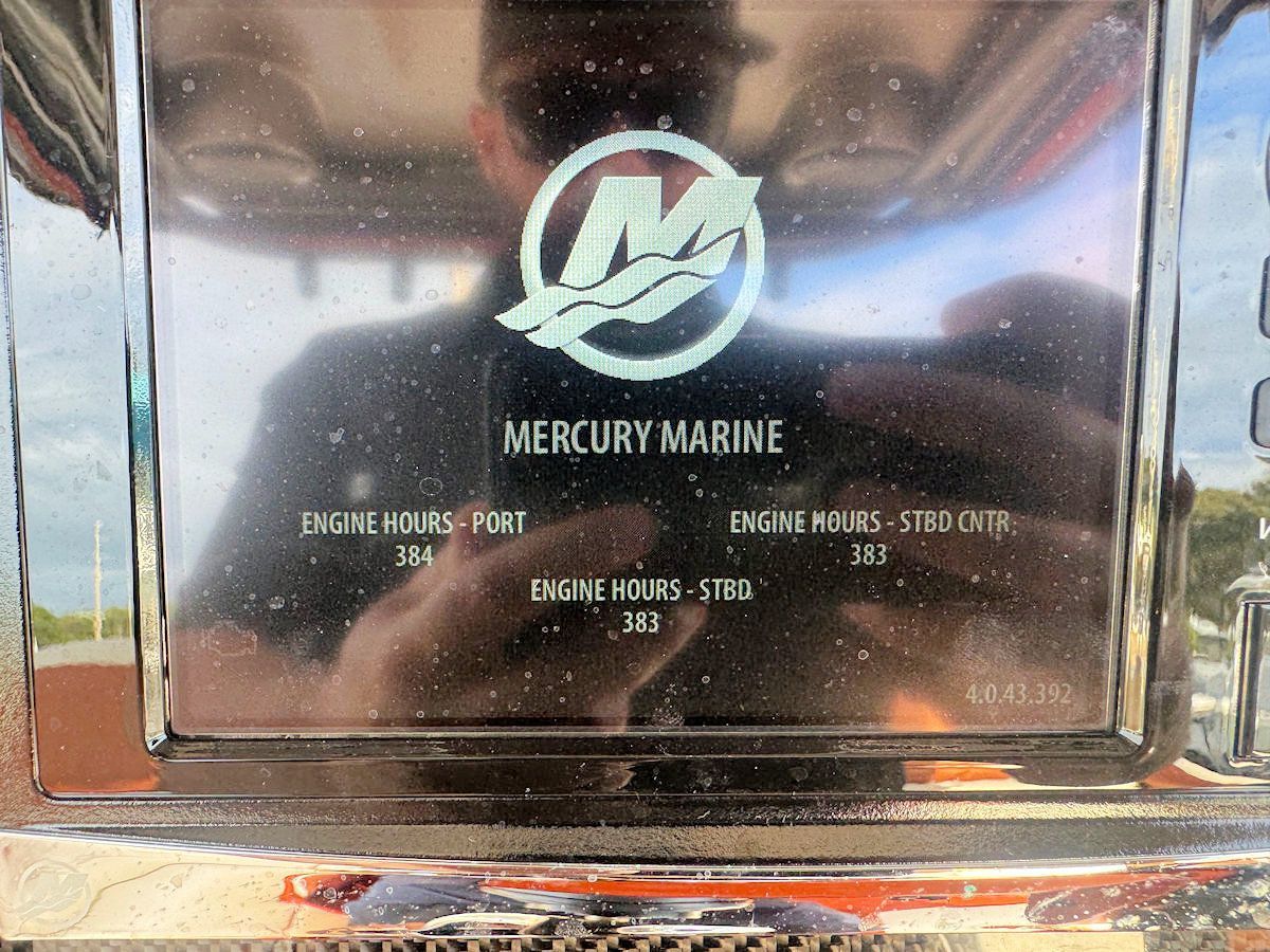 Mercury Marine gauge with engine hour readings, mirrored reflection.