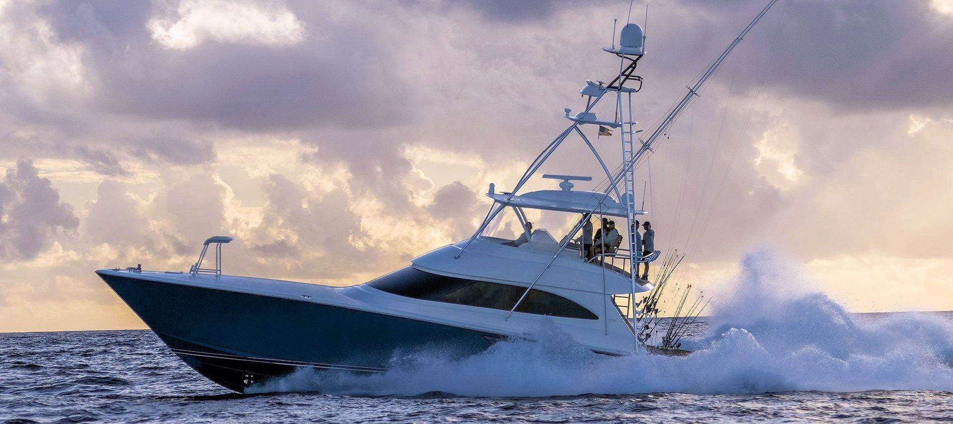 A white sport fishing boat speeds across ocean waves under a cloudy sky.